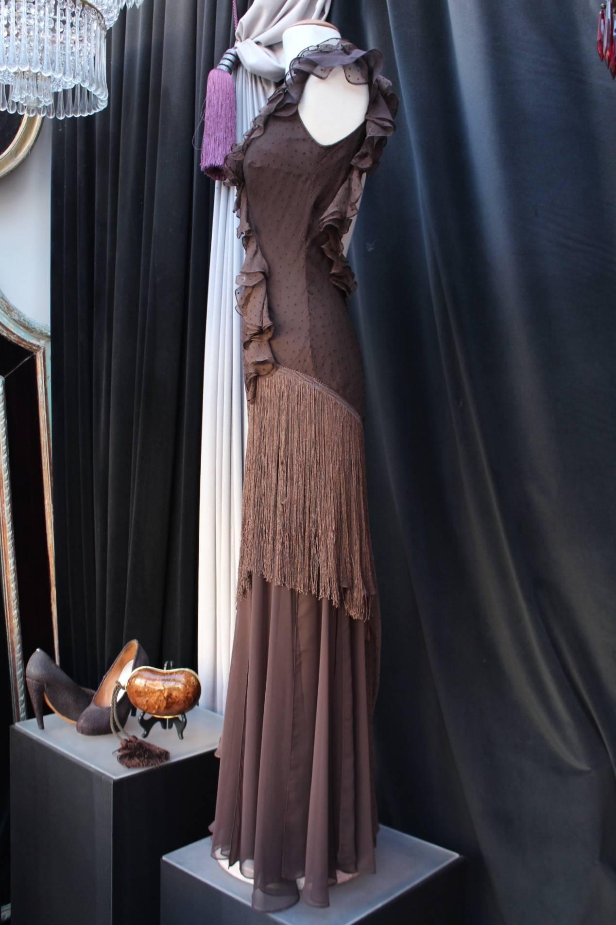 CHRISTIAN DIOR BOUTIQUE (Paris) Long evening dress constructed with brown silk muslin chiffon adorned with fringes and brown silk embroidered dots. 

The dress is constructed with thin straps and band of ruffles intersecting and joining the bias