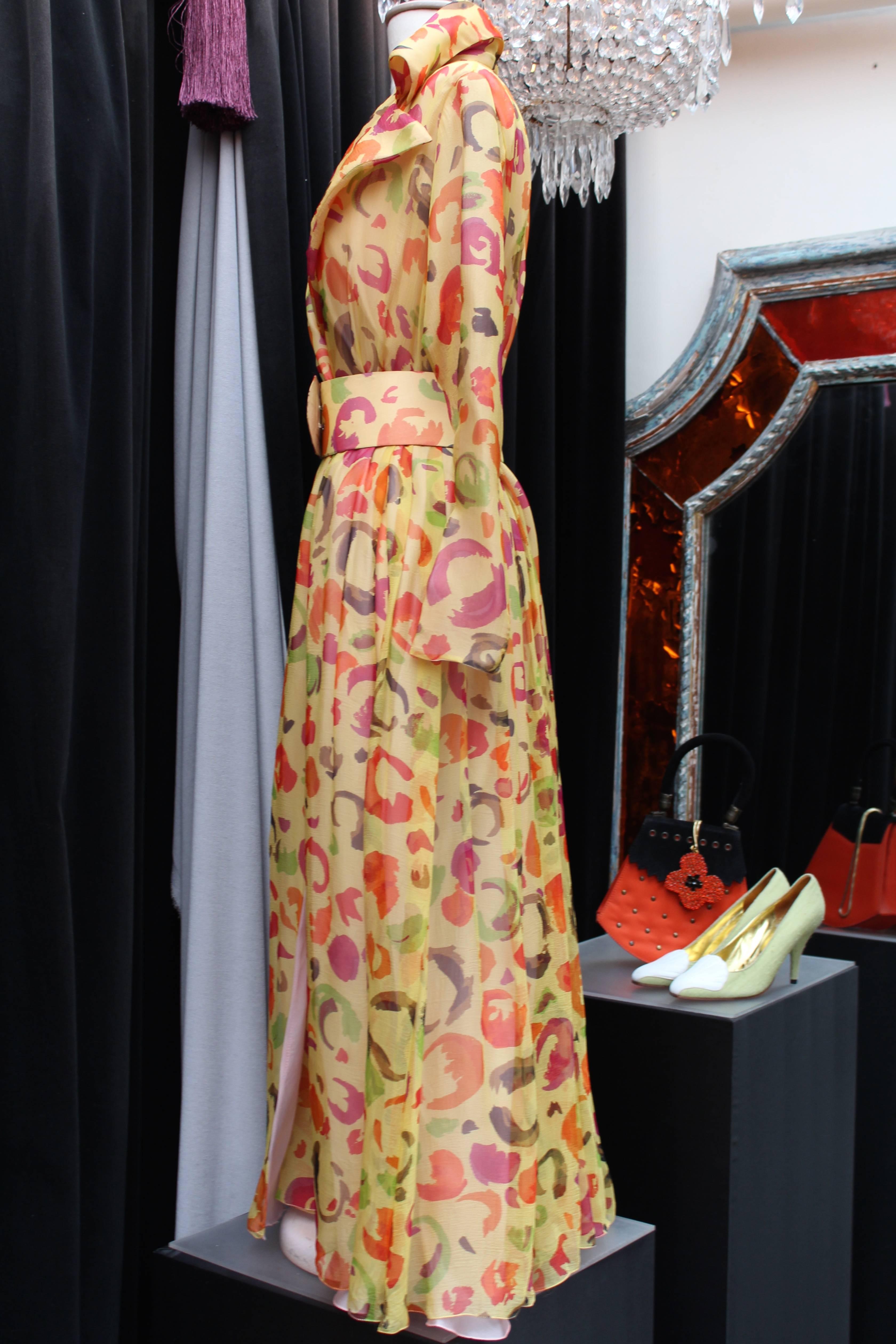 TED LAPIDUS (Paris) Wrap draped dress comprising of silk pulsing printed with a floral design in pink, purple and green on a yellow background. 

The dress is constructed of a large V collar, long sleeves, three press buttons and a removable rigid