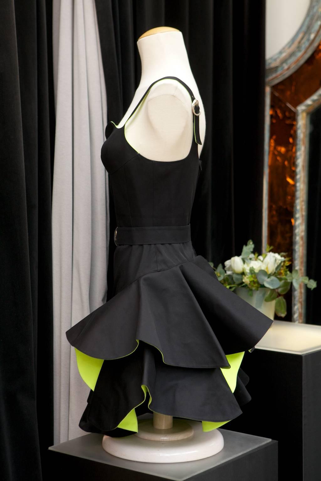 THIERRY MUGLER PARIS (Made in France) Short cocktail dress composed of cotton in black and apple green color, stylized with a black cotton belt fastening with a silver metal buckle. 
The same buckle is presented on the shoulder straps. 

The