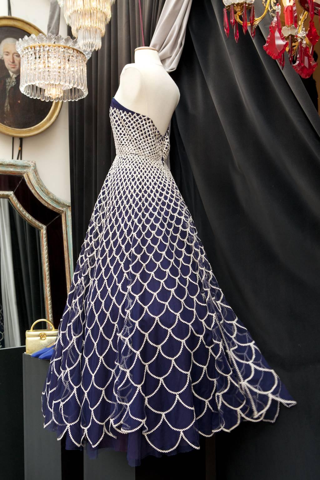 CLAIRE MANNERIE (Brussels- Belgium) 1950s gorgeous strapless navy blue tulle evening gown flared from the hips, embroidered in a gradient manner with white zigzag trims. 

Zip at the rear. Inner lining in an eggplant color satin. 

The dress has