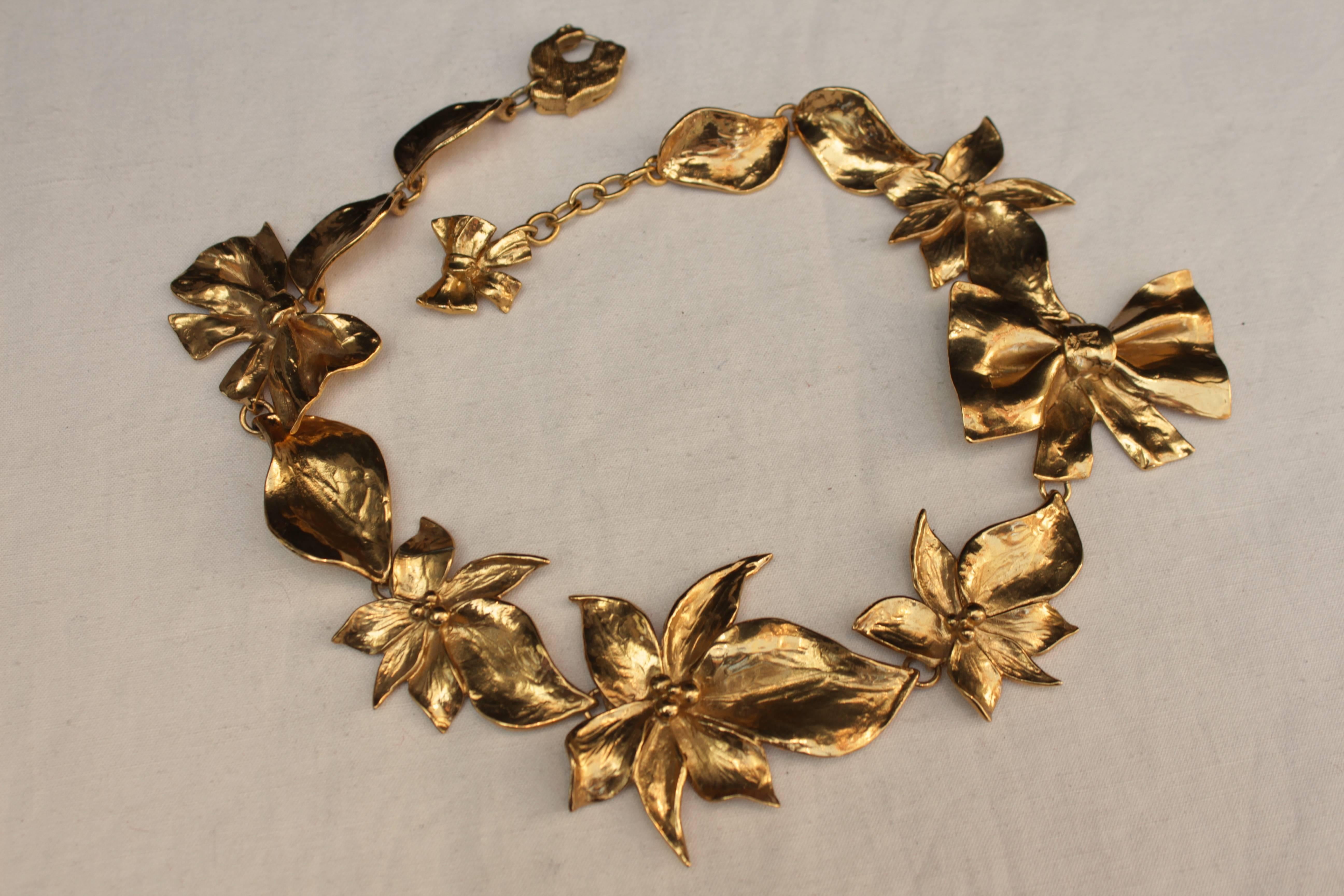 JEAN-LOUIS CHERRER (Made in France) Short necklace made of hammered gilt metal elements figuring flowers and ribbons. The clasp is in shape of a feline head, with trademark Scherrer.

Piece dating from the 1980s.

Very good