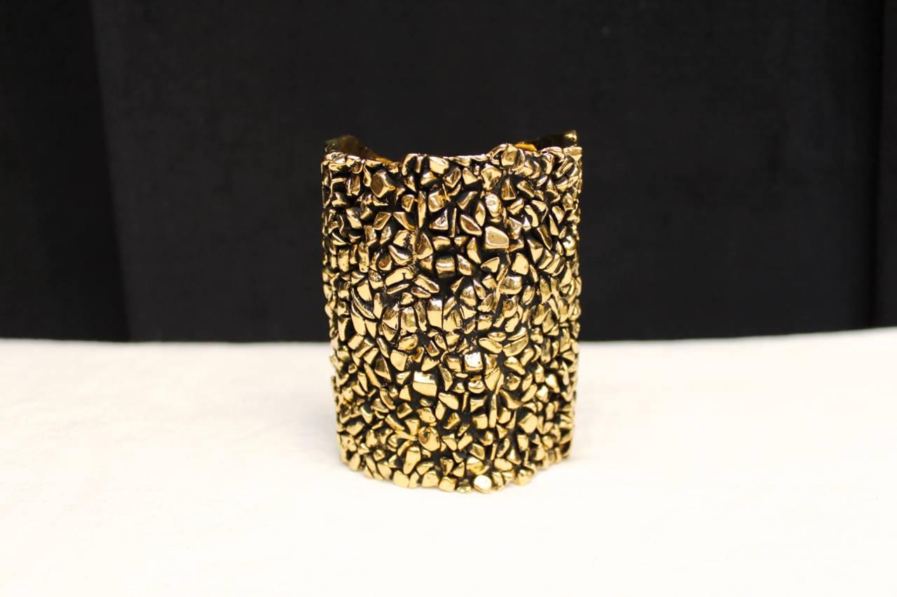YVES SAINT LAURENT - Textured gilt metal cuff bracelet composed of hammered and blackened metal imitating the appearance of raw crystals. 
Engraved Yves Saint Laurent inside the cuff.

Dates from the 1990s.

Very good