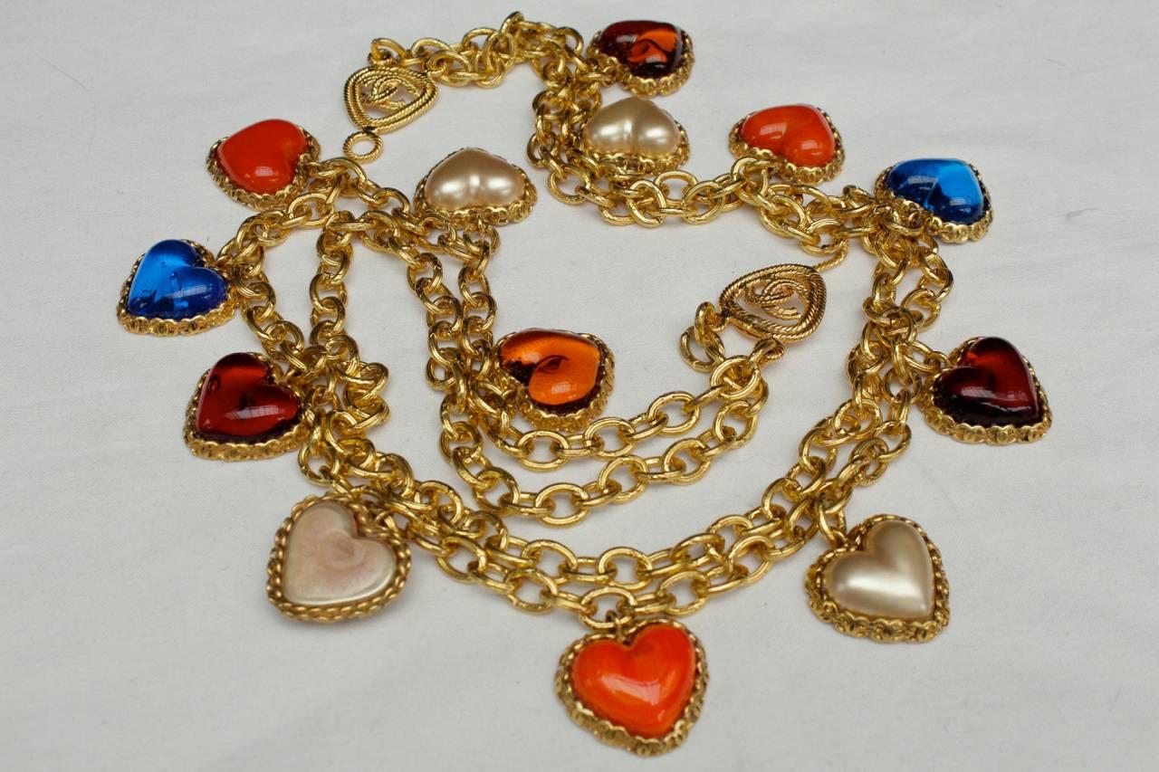 CHANEL (Made in France) Long double strands necklace comprising of gilt chain holding a series of heart shape glass and mother of pearl heart cabochons circled by gilt CC logos. 

Signed on a gilt plaque, Collection 2 9, from early 1990s. 

Very