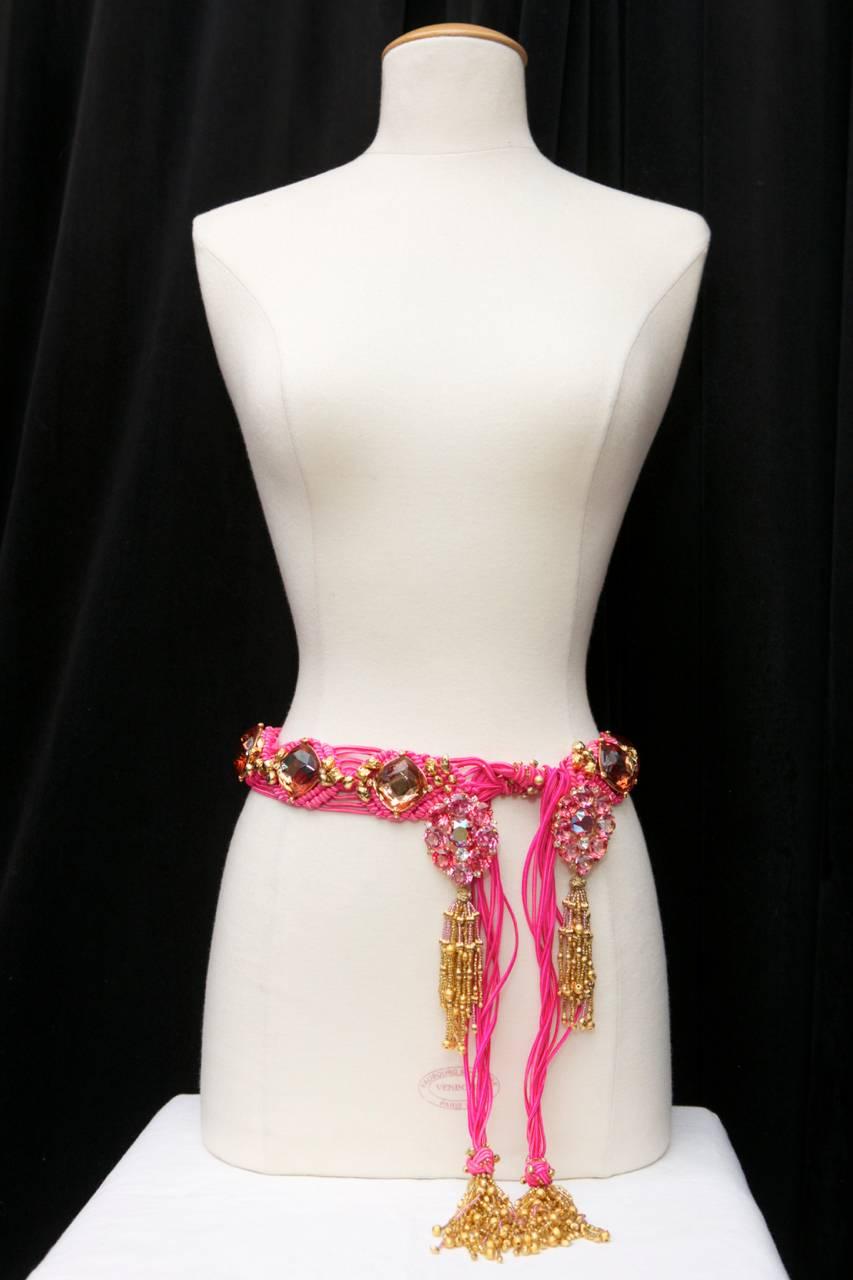 YVES SAINT LAURENT (Unsigned - Attributed to ) Beautiful belt in fuschia pink passementerie embroidered with large amber colors crystals, gilt nuggets beads, and two large pink crystals in a shape of flowers, mounted on gilded metal structures.
