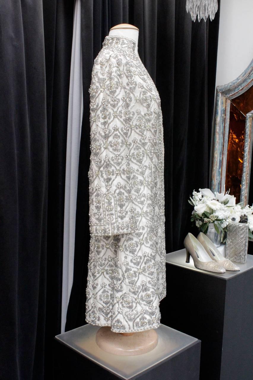 Exceptional evening coat hand-made composed of beige raw silk embroidered all over with silk threads, small gray pearls, faux-pearls, sequins and rhinestones. 

French embroideries in exceptional condition all hand made. 

Two pockets on the