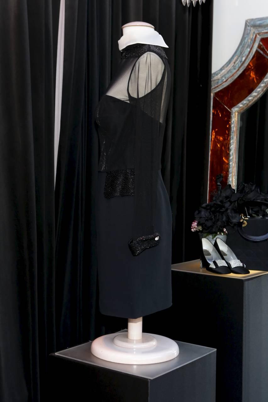 CHRISTIAN DIOR BOUTIQUE (Made in France) Sumptuous black bi-material cocktail dress with a removable silk white reversed collar and embroidered collar, pockets in trompe l'oeil and wrists with small shiny black beads. 

The dress is constructed like