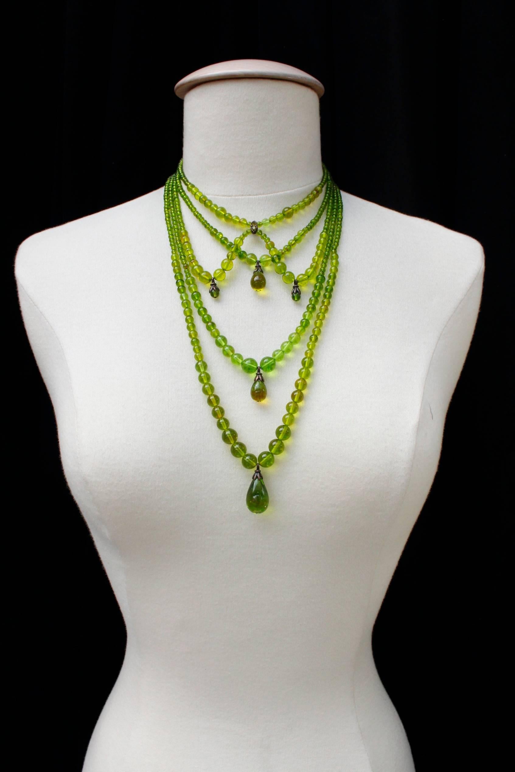 CHRISTIAN DIOR BOUTIQUE (Made in France) Long statement necklace composed of five rows of green glass beads mounted on wire. 

Each row of beads includes a drop bead surmounted by a blackened silver metallic post. 

The hook clasp is in blackened