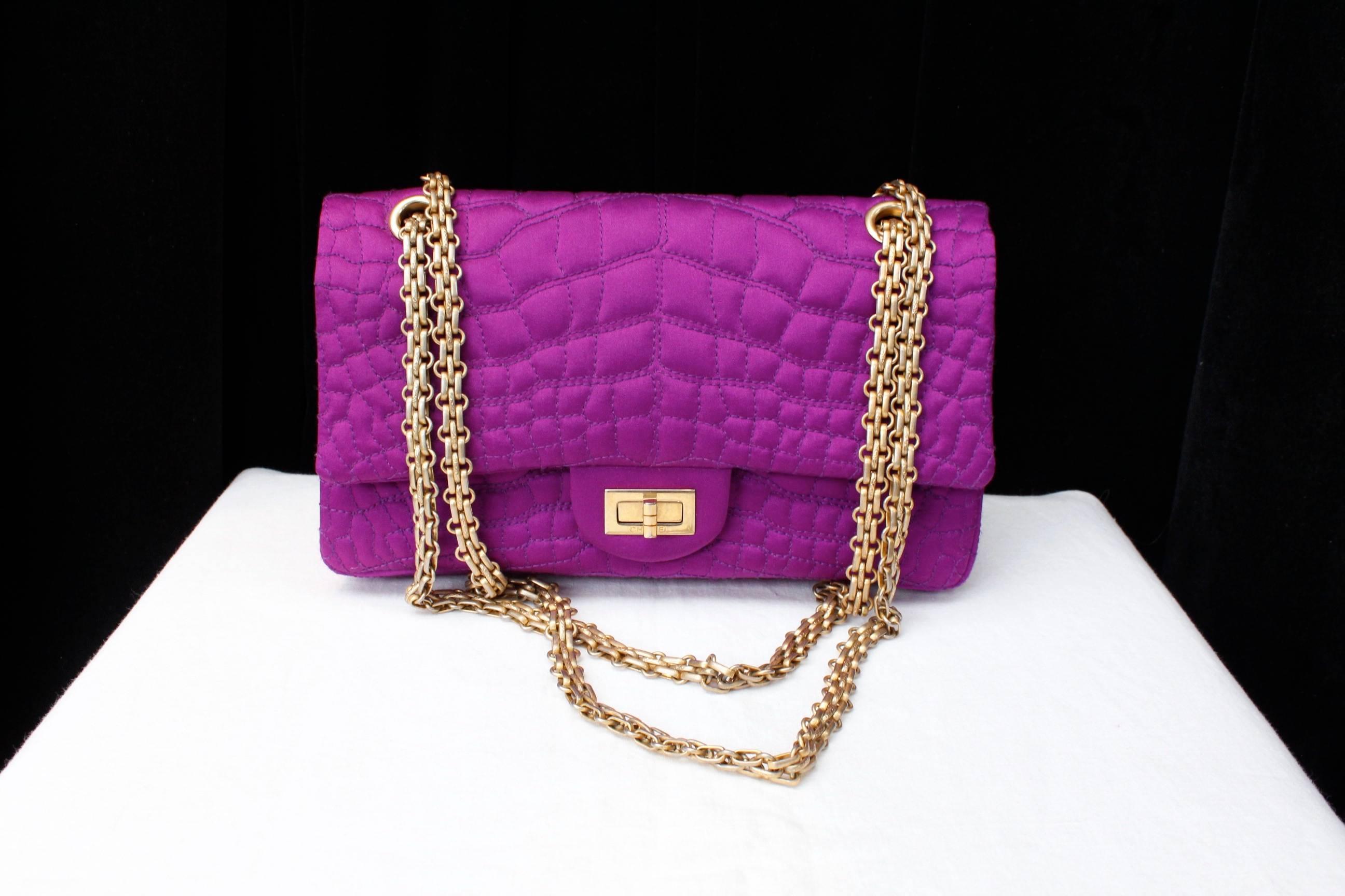 CHANEL (Made in France) Medium-sized 2-55 bag in purple silk satin stitched with a quilted crocodile pattern and embellished with a mademoiselle gilt clasp and a sliding handle gilt jewel chain.

Double flap, one of which is decorated with a zipped