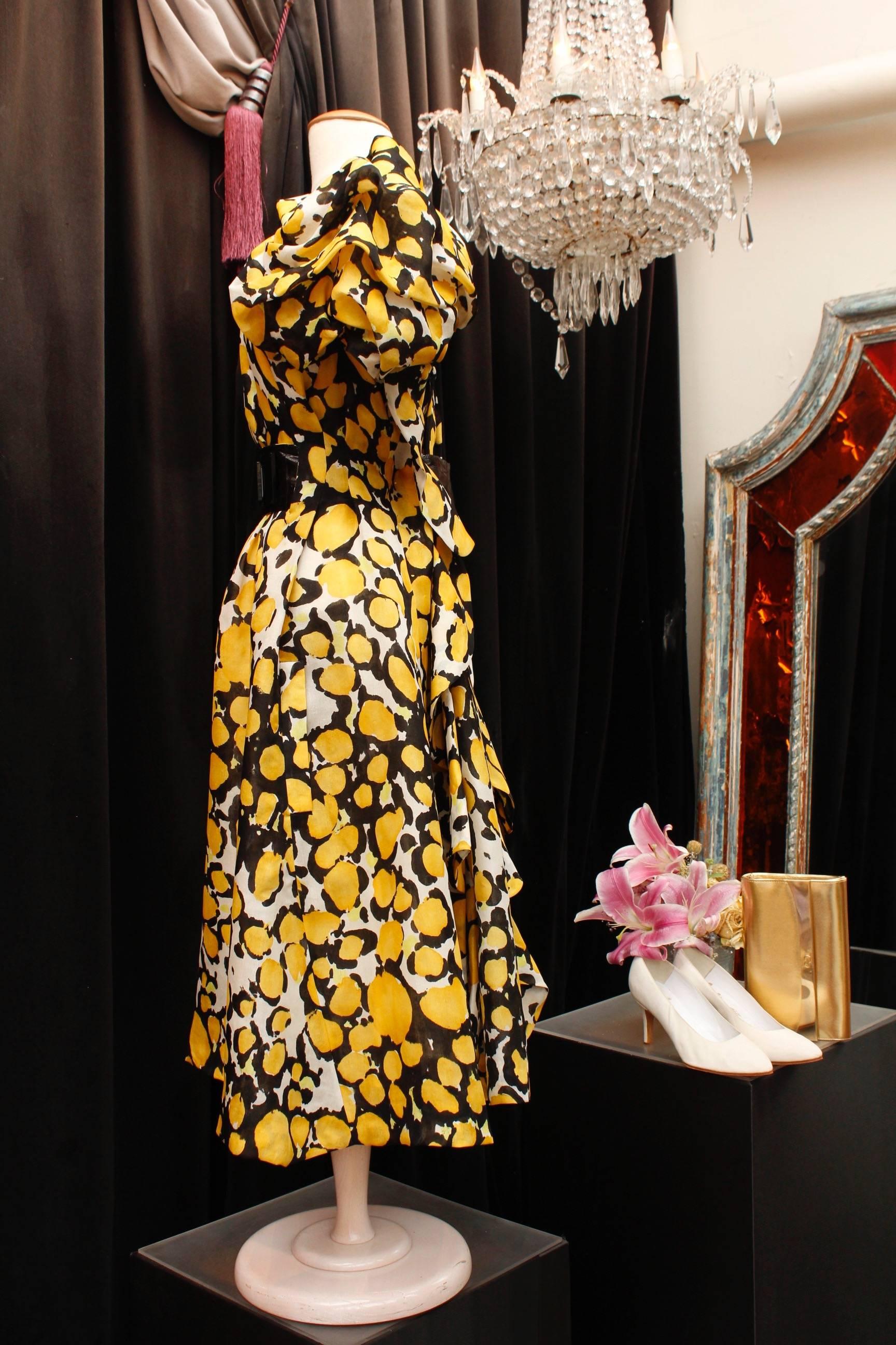 CHRISTIAN LACROIX (Made in France) - 1980/1990s - Long white organza dress with abstract floral pattern in yellow and black. The waist is emphasized by a wide reversible belt; one of its side is made of organza, the reverse of  black eel leather