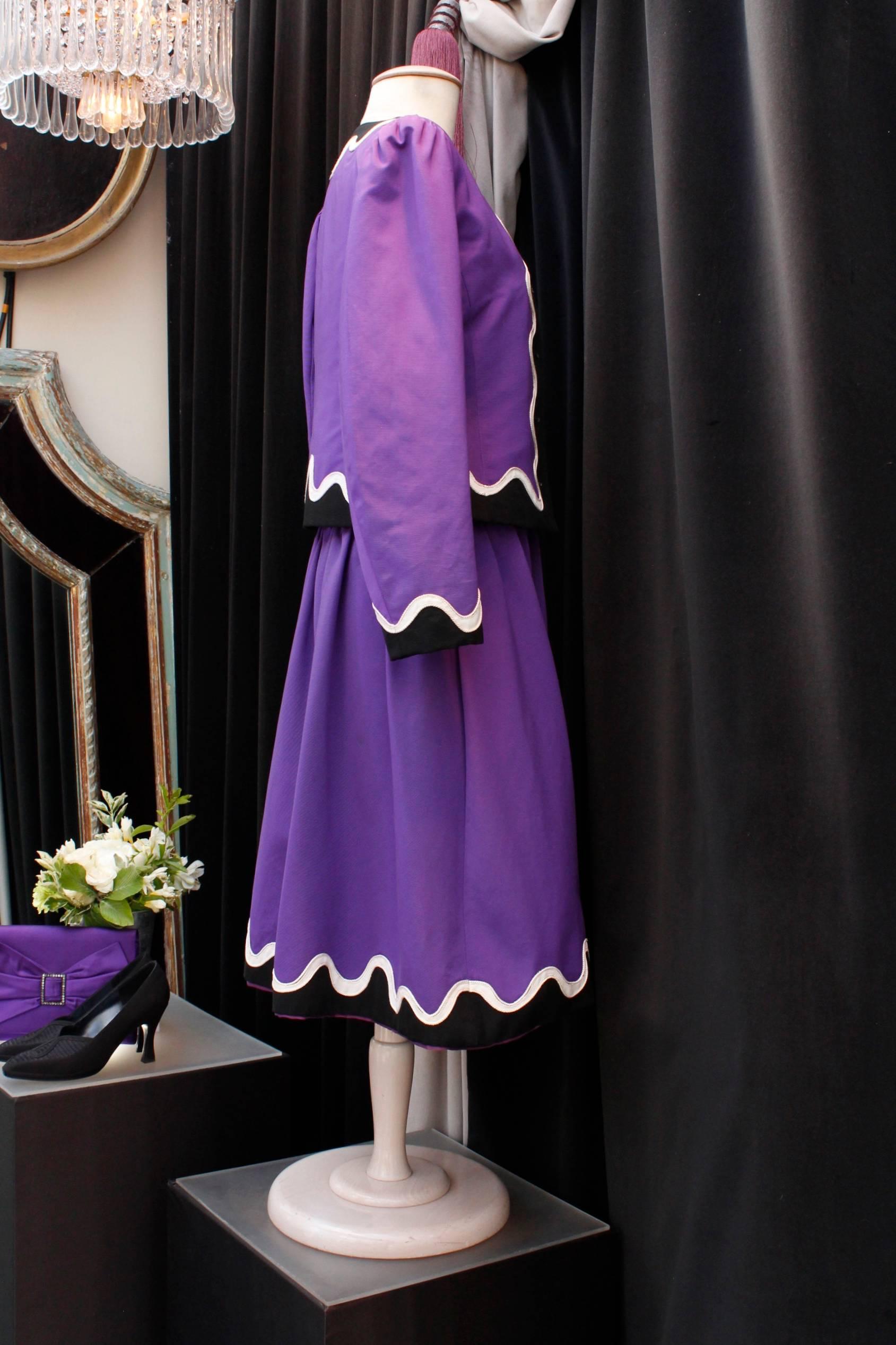 YVES SAINT LAURENT RIVE GAUCHE (Made in France) Dress and short jacket set in purple color, decorated with black passementerie and black and white fabric with wave pattern at jacket and dress edges and neckline. Calf length dress with thin shoulder