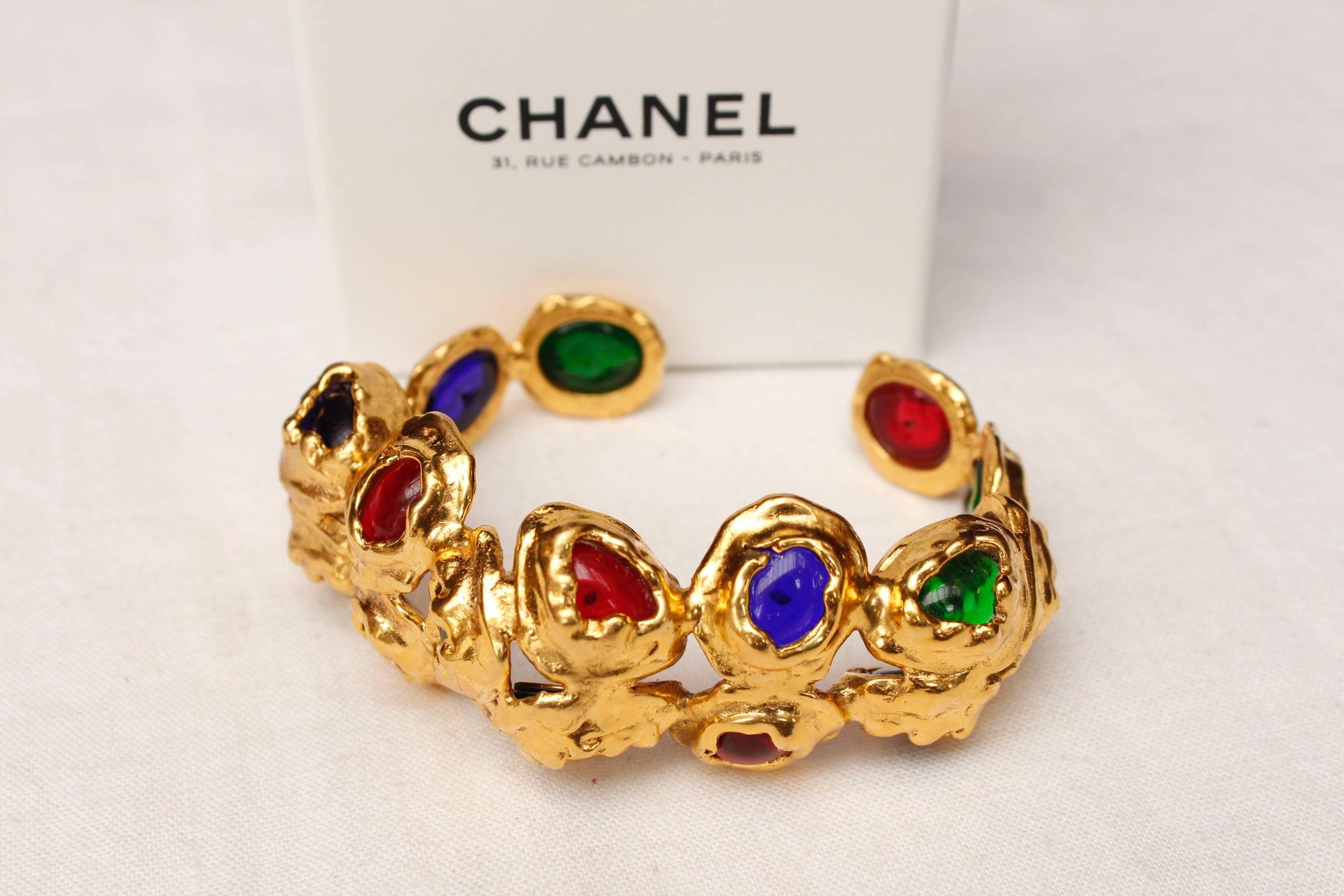 CHANEL (Made in France) Hammered gilded metal baroque bangle set with ruby, sapphire, and emerald glass paste cabochons.

Signed inside.

2cc9 Collection from the early 1990s.

Very good condition.


Dimensions: Wrist circumference 15 cm (6 in);