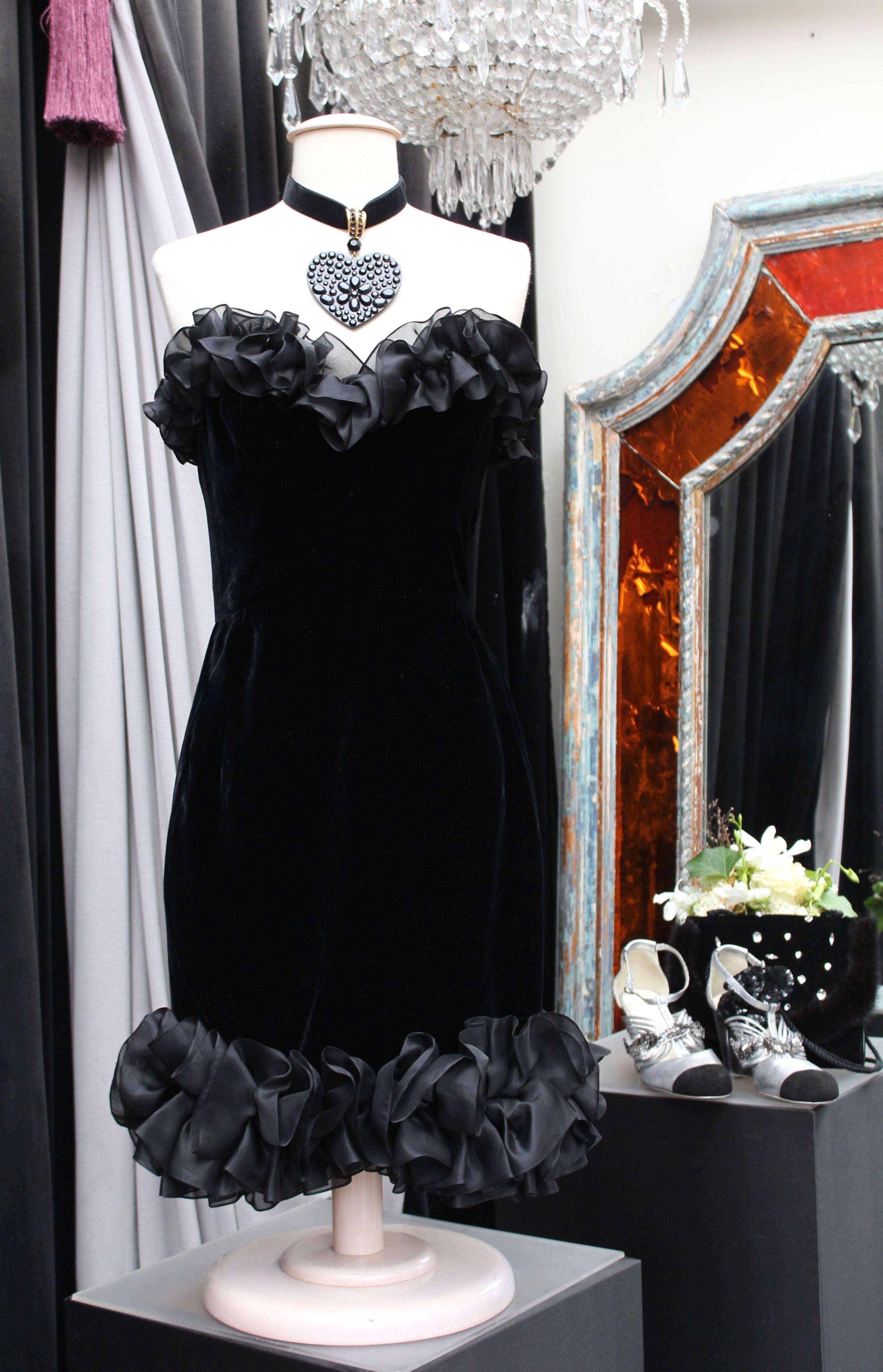 YVES SAINT LAURENT RIVE GAUCHE (Made in France) Bustier dress in black silk velvet, trimmed with silk flounces at bust and hemline. No lining. Side zip closure.

1987 Winter Collection.

Size 38 (US 6 M).

Length 80 cm (31.5 in); Bust 40 cm (15.75