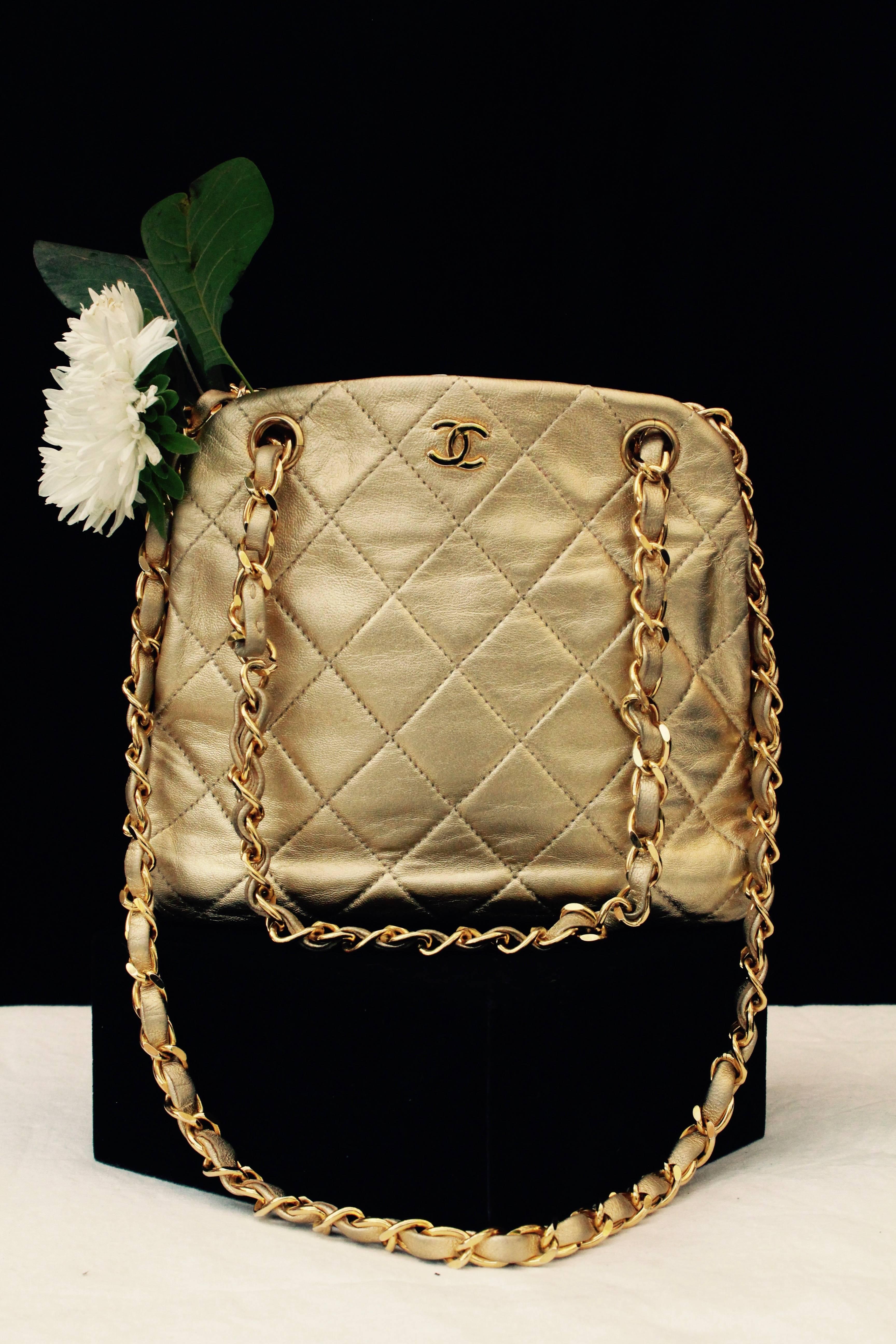 CHANEL (Made in France) Small vintage golden leather bag quilted with thin over stitching. Two small gilded metal straps entwined with golden leather. Gilded metal purse clasp. Golden lining with stamped signature in gold letters.

Serial number