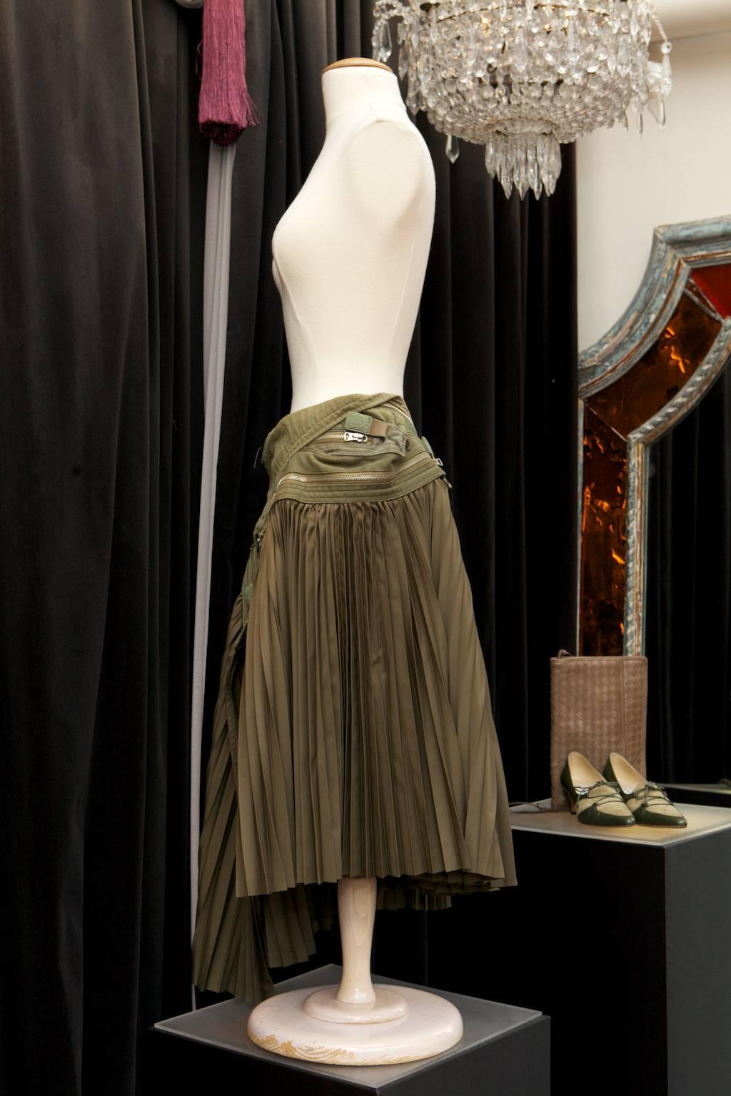 JUNYA WATANABE – COMME DES GARCONS (Made in Japan)  Unusual khaki cotton and parachute cloth skirt. It features a wide military inspired unstructured belt on the hips, composed of khaki cotton and decorated with a wide decorative silvery zip as well