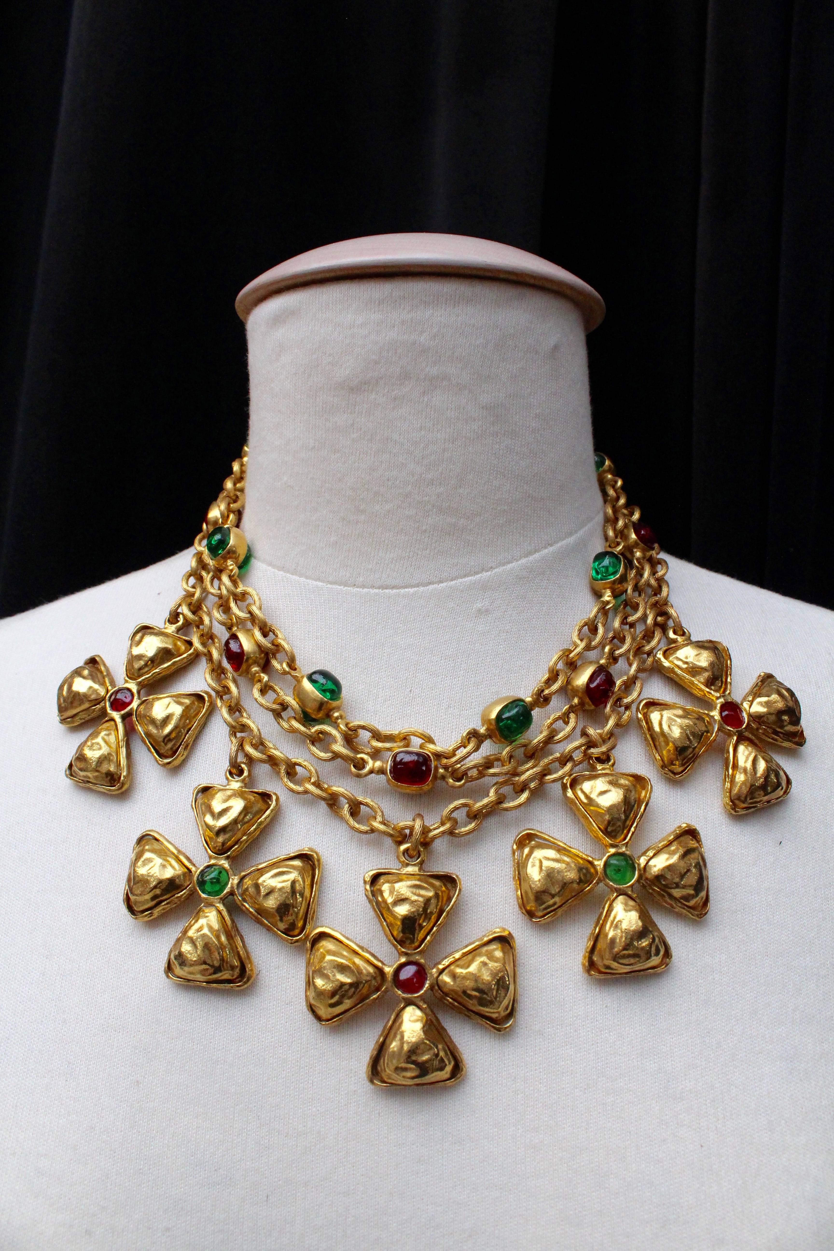 CHANEL (Made in France) Choker comprised of three strands of gilded metal chain decorated on the two shortest strands with emerald and ruby glass paste cabochons set in gilded metal.  Five pendants representing Maltese cross are hanging from the