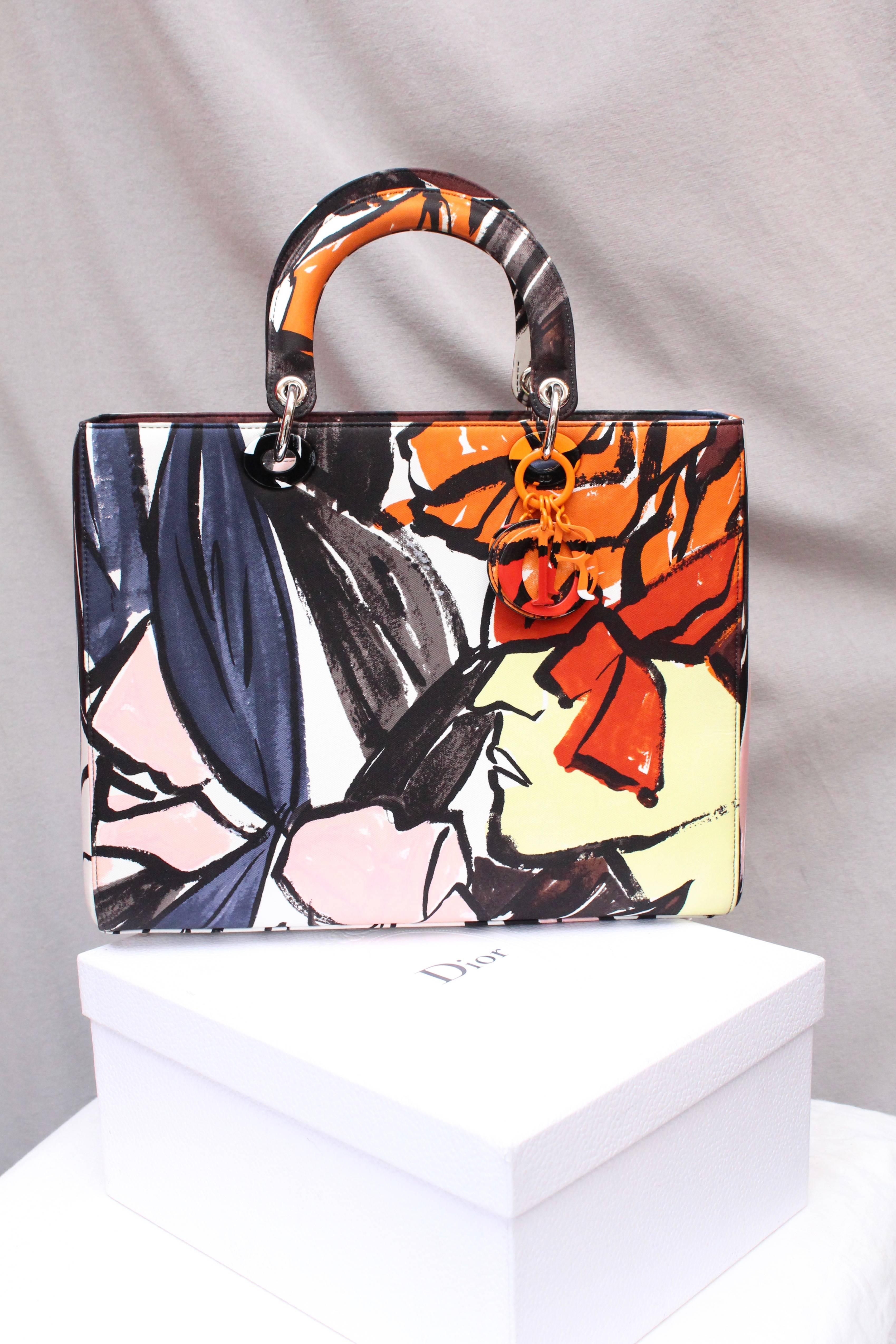 CHRISTIAN DIOR (Made in Italy) Large canvas Lady Dior Floral Graffiti Limited Edition by Raf Simons. It can be worn over the shoulder thanks to ots removable shoulder strap, or by hand. A colored metal key holder representing the brand initials