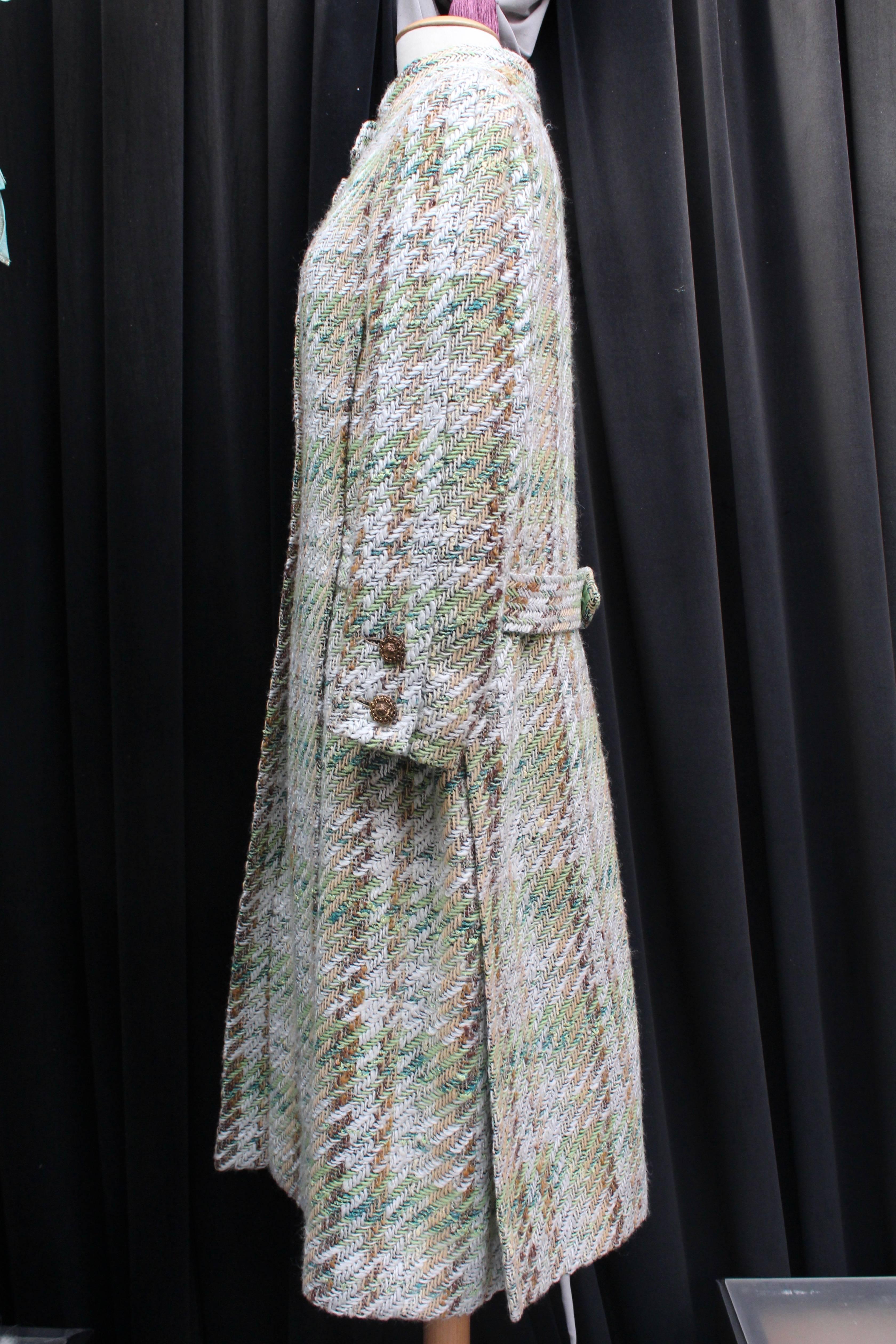 CHANEL HAUTE COUTURE (Made in France)  Set comprised of a coat and a long skirt made of thick wool tweed in brown, green white and yellow colors.

The long coat features a high collar fastening with a placket piece. The coat copper-tone round