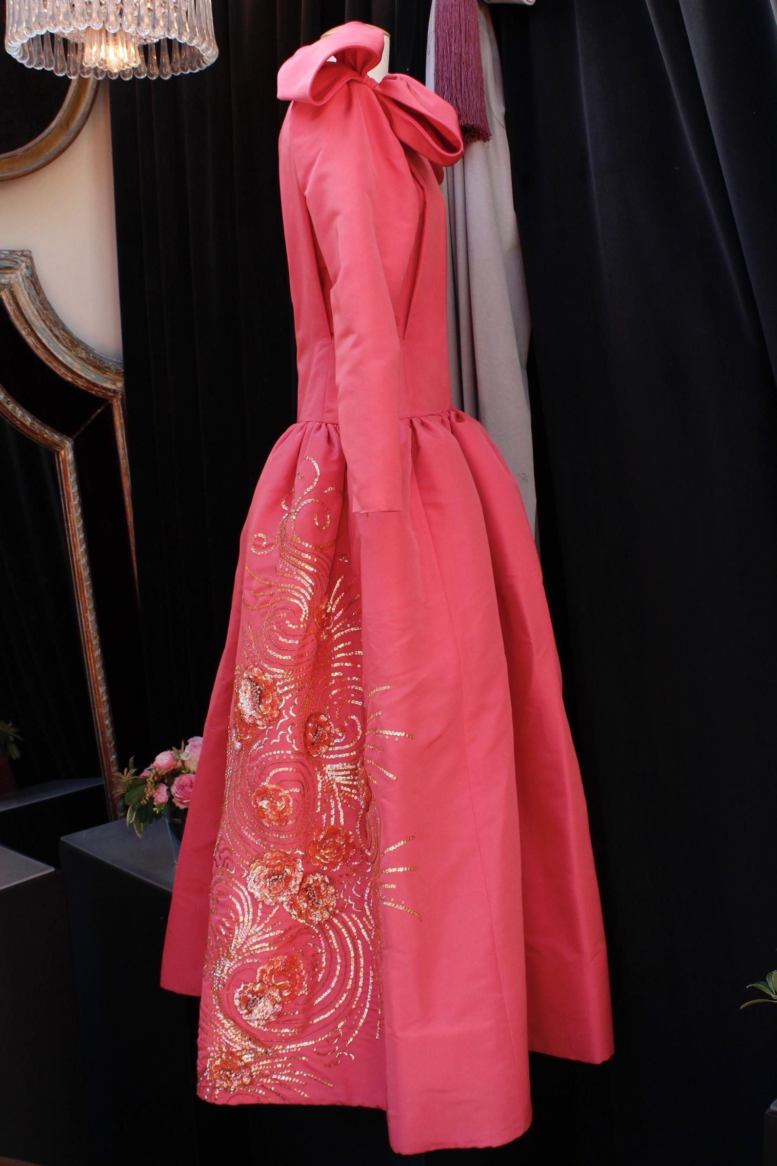 Nina Ricci (Made in France) Stunning opera dress composed of pink silk taffeta. The top features a close-fitting cut with a boat neck and long sleeves so tight they have a side zip at cuffs. The gored skirt is flared, from the waist to the ankles.