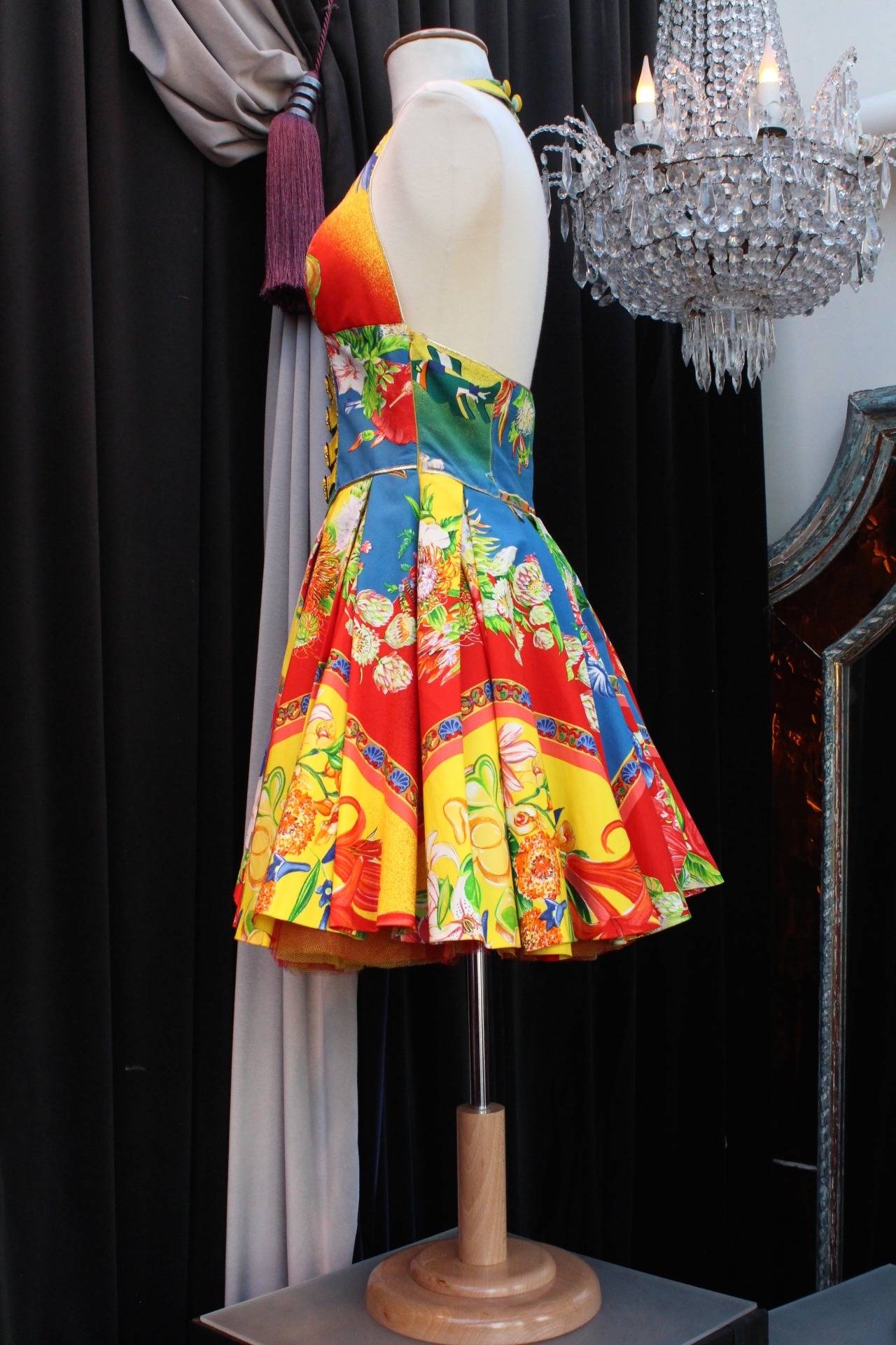 Fresh and happy corset mini dress from Versus by Gianni Versace from the 1993 spring collection. 

The dress is composed of floral printed coton with bright and dynamic colors (yellow, green, blue, red, etc.) and features a corset and a flare
