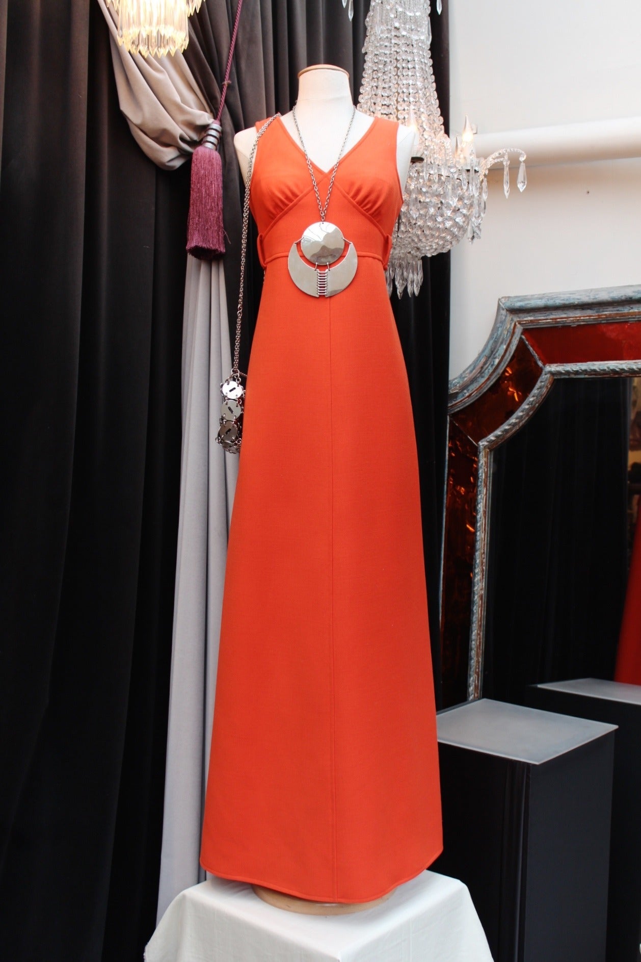 Happy and fresh orange wool sleeveless long flare dress Courreges Couture Future from the Space Age 1967 Collection. 

Adorned with a V-neck and a orange wool belt (which closes thanks to small hooks), this dress closes thanks to a zipper located