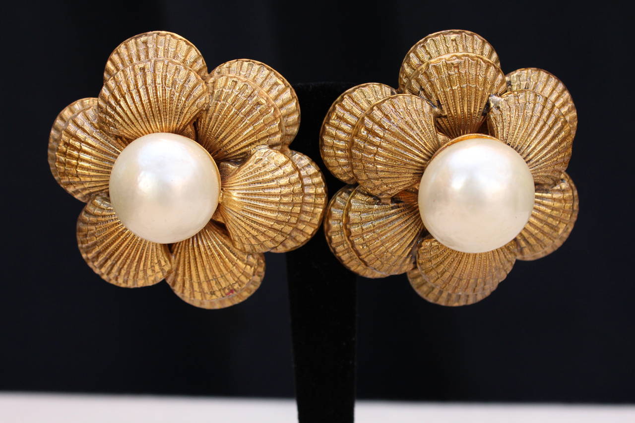 Stunning Large Chanel pair of clip-on earrings with a clam shell motif made of chiselled gold metal centered with a faux pearl cabochon. 

Very good condition. One earring shows a bit more wearing marks. 

Diameter: 
5,5 cm