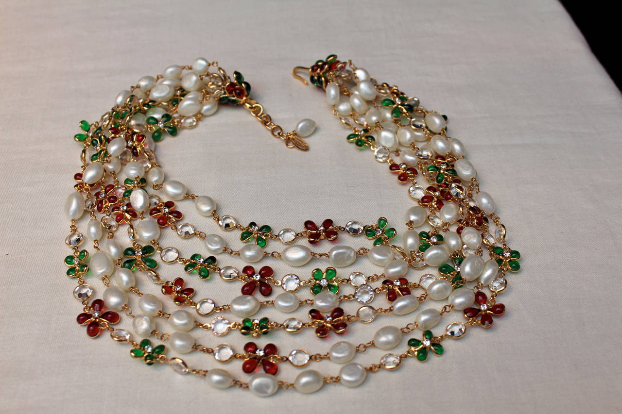 Magnificent multi strand Chanel necklace composed of red and green glass paste flowers centered by a Swarovski crystal and alternated with round cut see through crystals and faux pearls. 

The length of the necklace is adjustable thanks to a gold