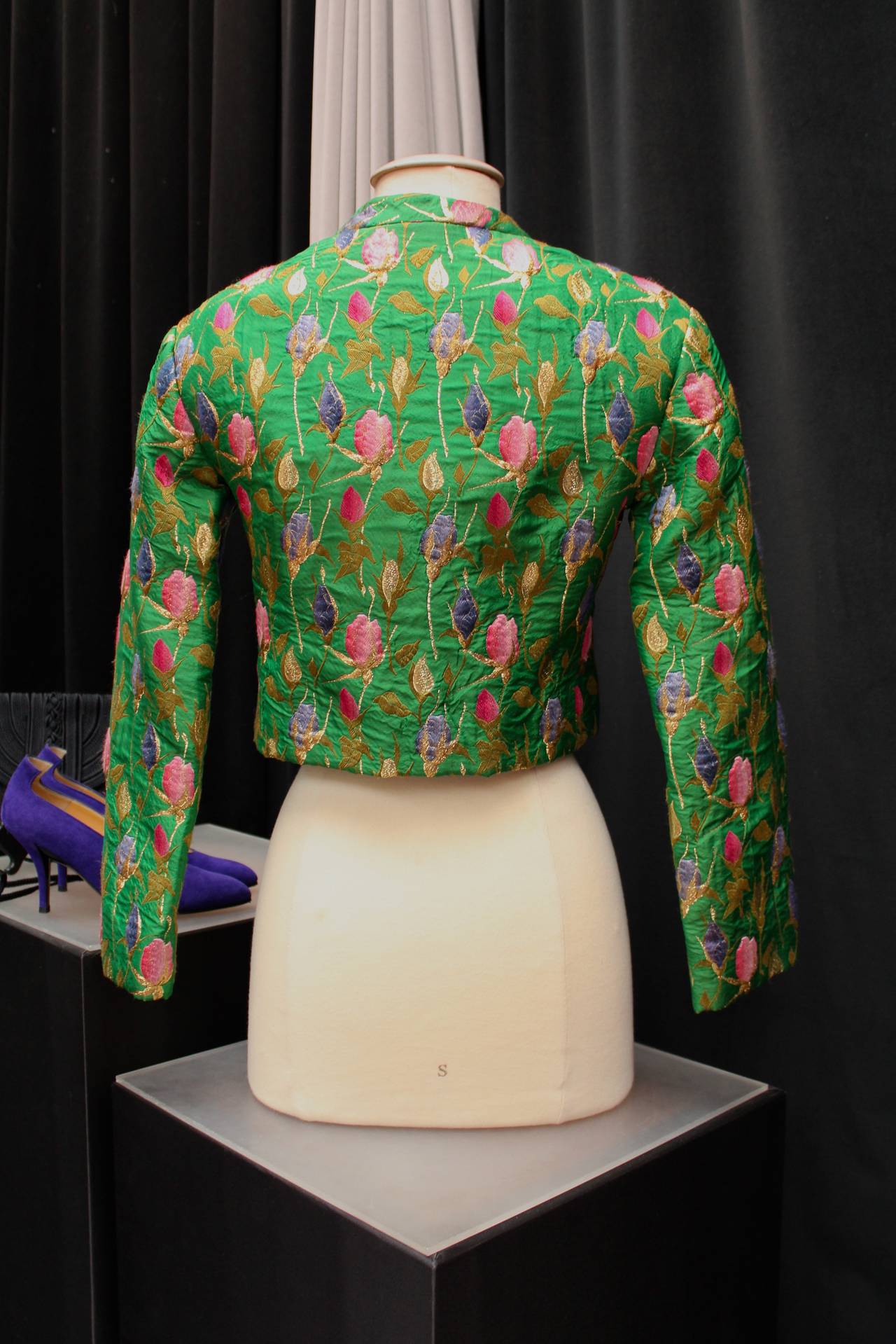 YVES SAINT LAURENT BOUTIQUE (Made in France) Short handmade Couture Jacket from the 1960's composed of green silk taffeta embroidered with silk thread featuring purple, pink, fuchsia and lame flower buds. The long sleeves jacket closes with a