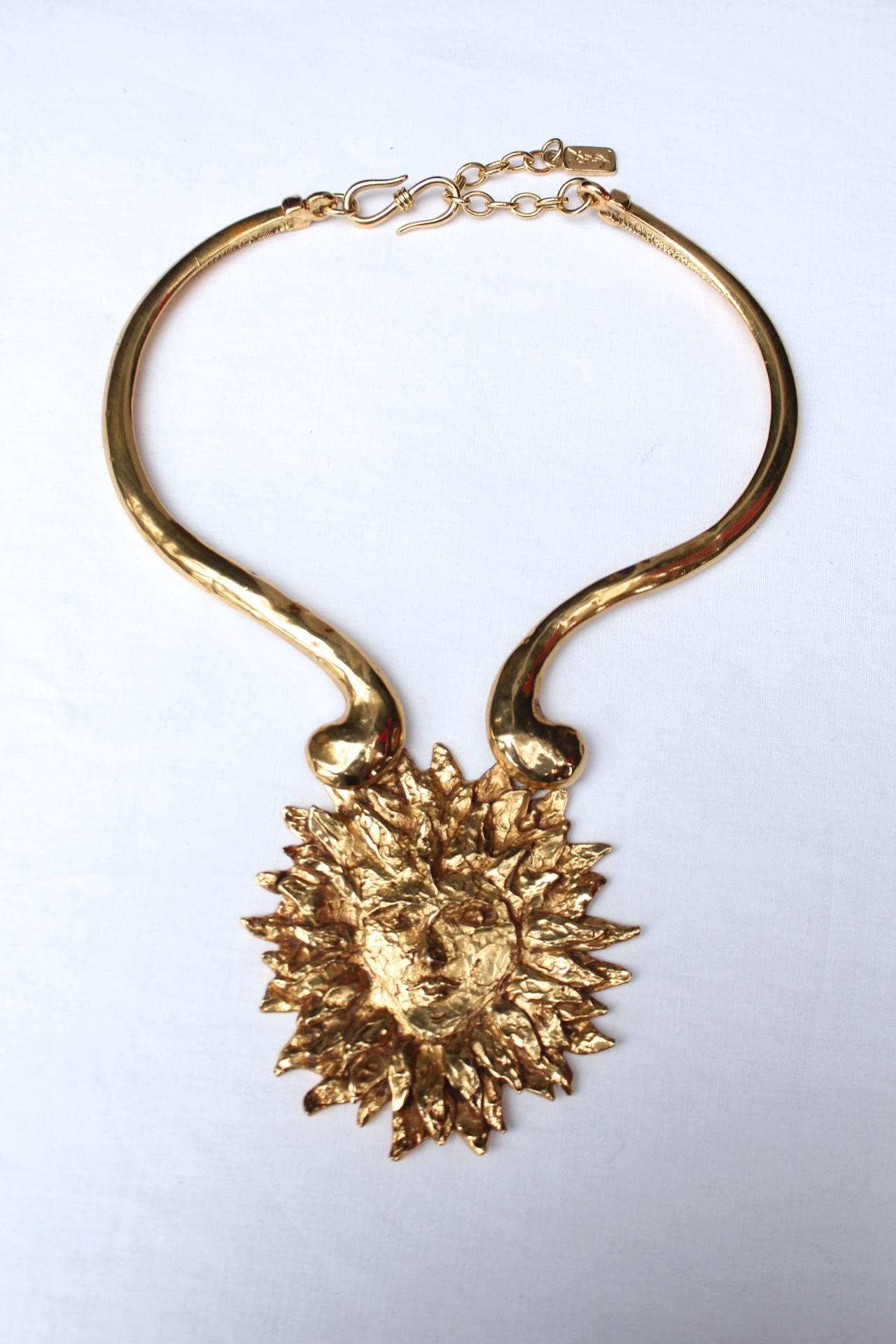 YVES SAINT LAURENT (Made in France) Rare torque necklace with the sun face in hammered gilt metal designed by Robert Goossens in the 1980s for Yves Saint Laurent.

A same model is included in the collection of Barbara Berger which was exhibited in