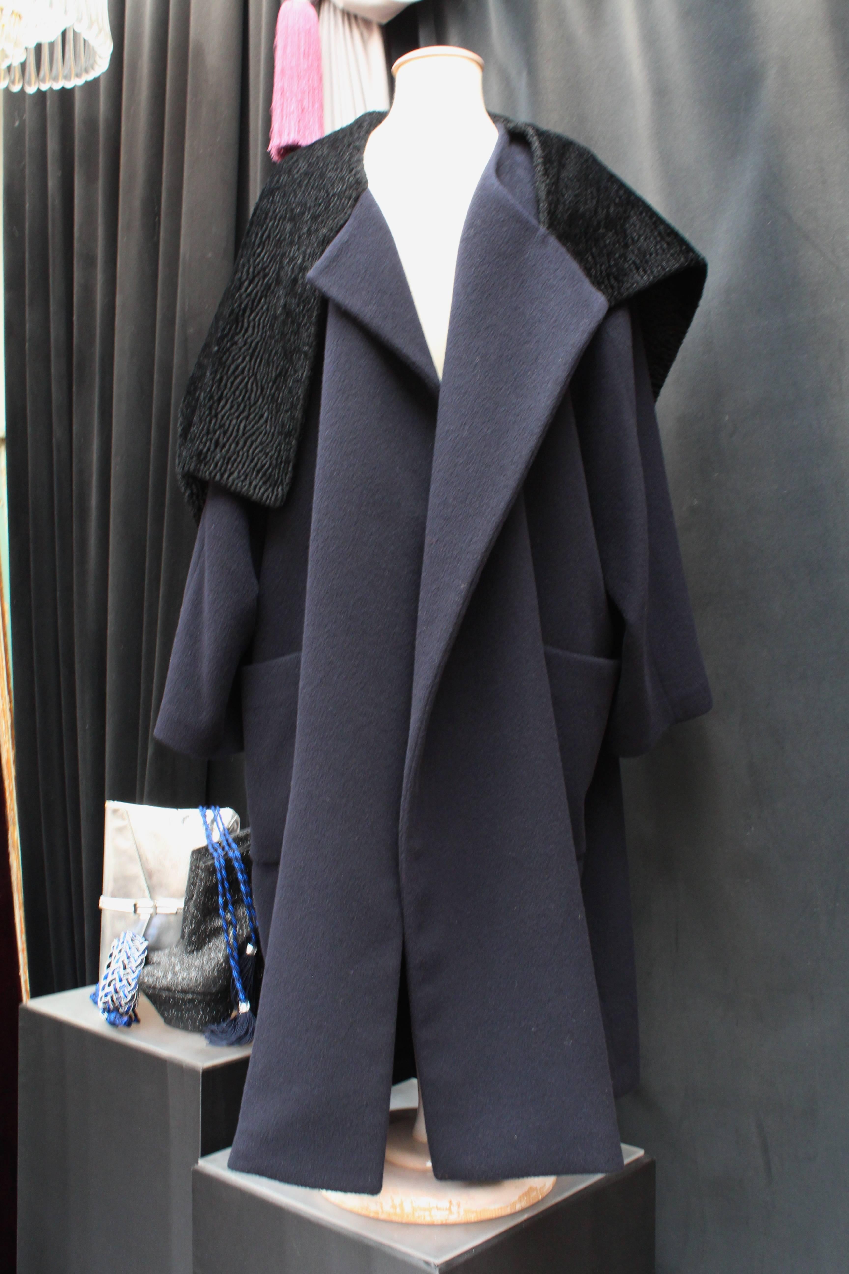 COMME DES GARCONS Oversized coat comprised of navy blue wool and a black chenille wool large collar in the style of astrakan.

The straight coat features two pocket in the front and a black satin lining. 

There are no buttonhole on the coat,