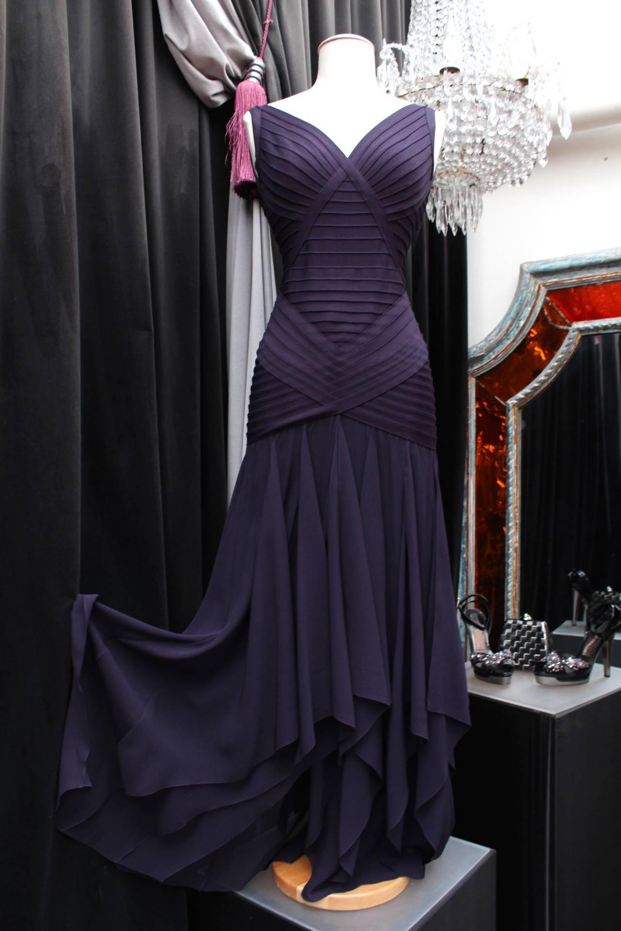 HERVE LEGER COUTURE (Made in France) Beautiful evening gown in purple rayon and pleated silk muslin frills. 

The dress is constructed with a top with a V neck and straps. It closes with a zip in the back. 

Extremely sexy dress designed by