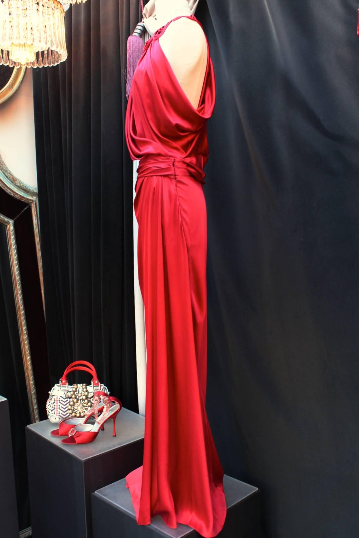 JOHN GALLIANO (Made in Italy) Red silk evening gown constructed with a stylized collar, a loose top with a V neck and crossing pans of silk in the back. The dress has also an asymmetrical waist band and skirt. 

Very beautiful and sexy gown.