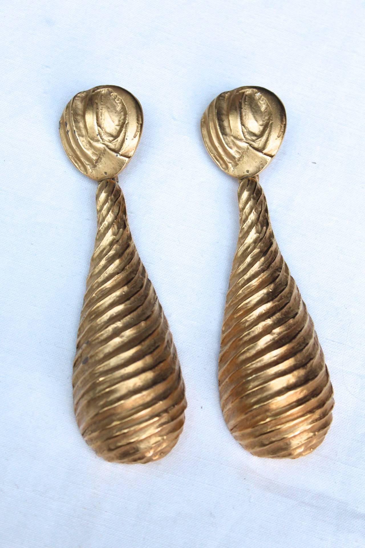 YVES SAINT LAURENT (Rive Gauche Made in France) Important pair of pendant clip on earrings clips with chiseled gilt metal from the 1980s. 

These earrings are photographed in the book on Loulou de la Falaise, which designed them for Yves Saint
