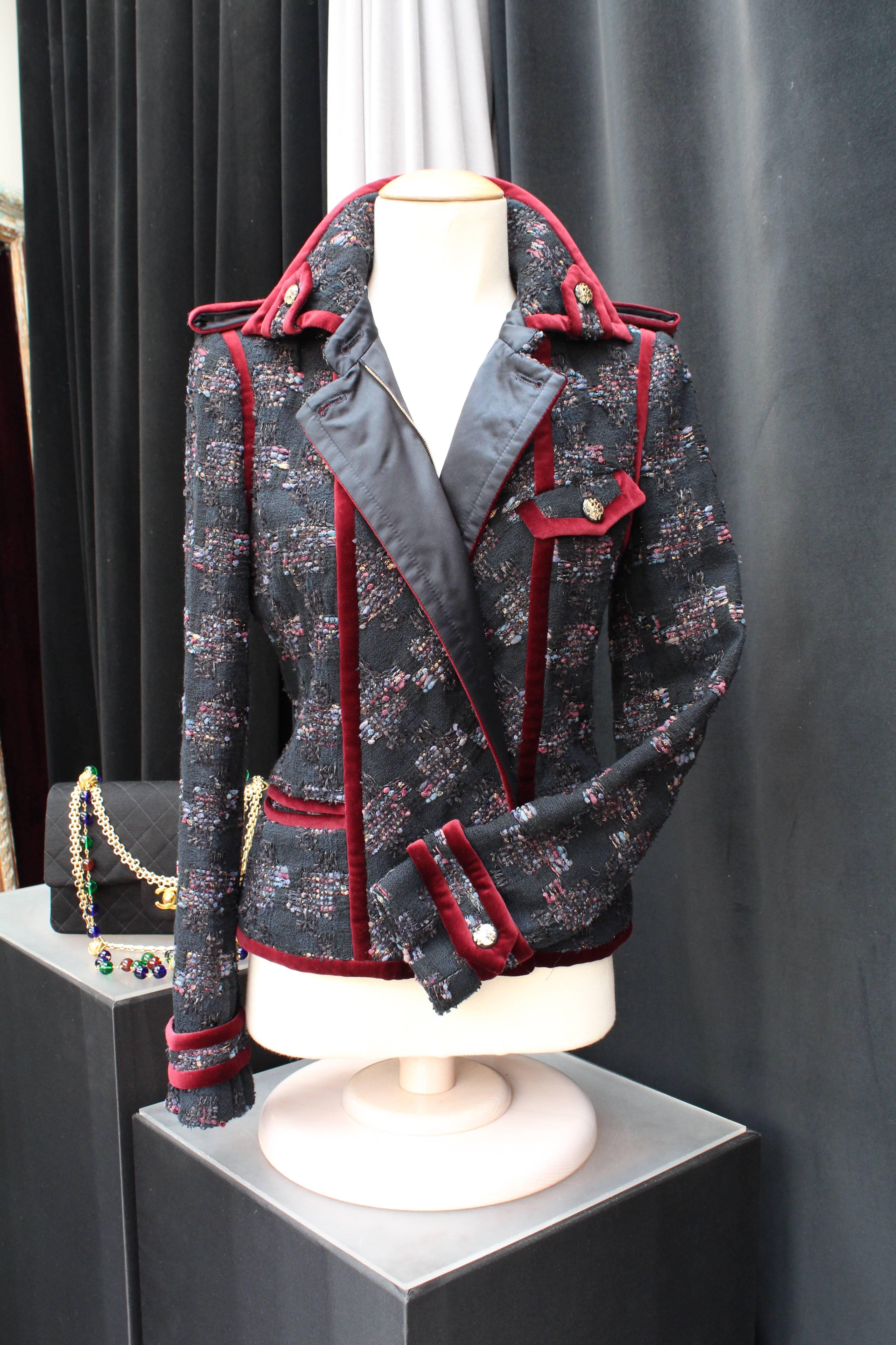 CHANEL (Made in France) Officer style jacket comprising of black woolen tweed interlaced with red, blue and gold wool threads and adorned with burgundy velvet galloons from the Pre-Fall 2009 collection Paris-Moscow. 

The jacket fastens in the