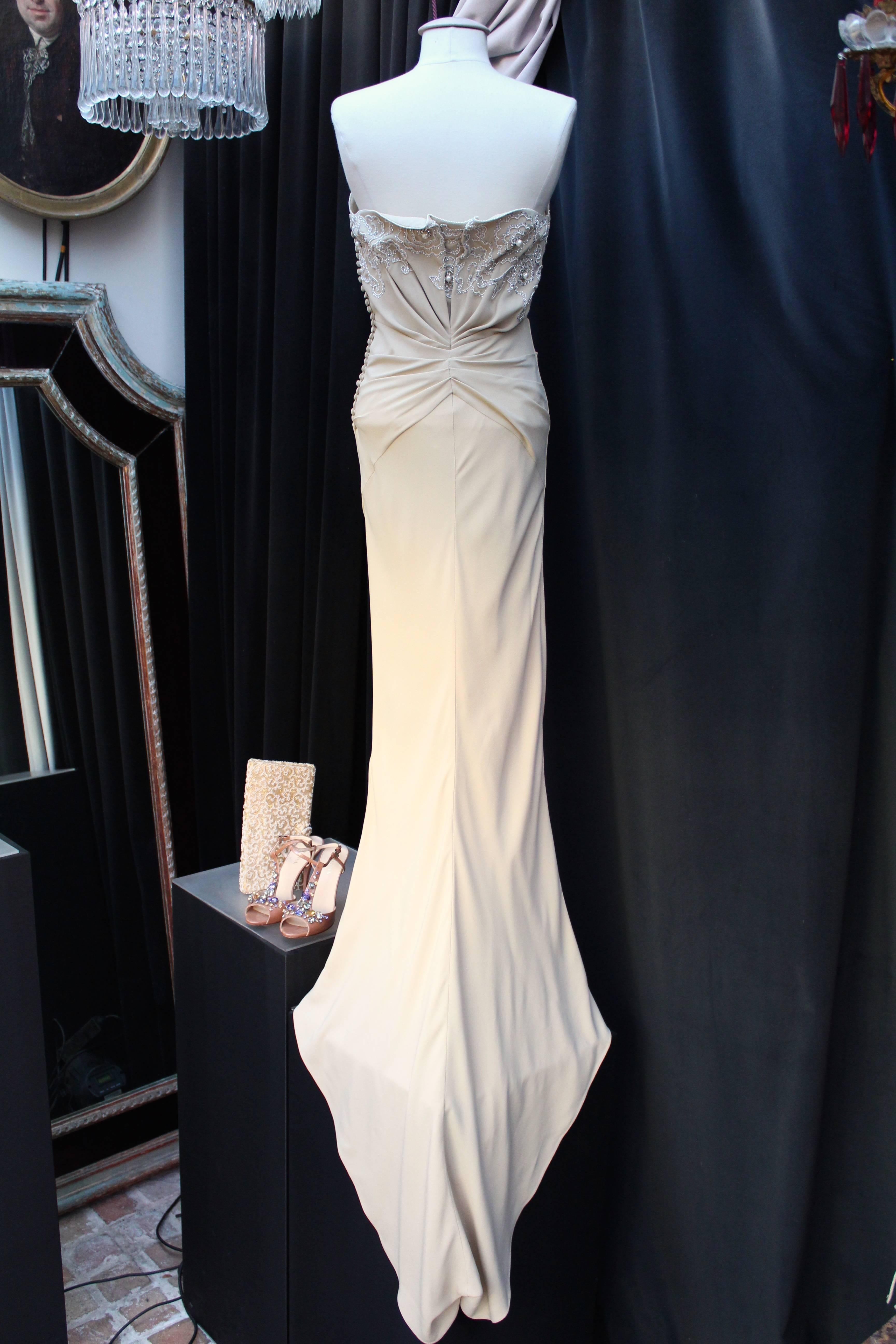 CHRISTIAN DIOR PARIS (Made in France) Long pencil asymmetrical draped gown in ivory/sand/beige silk embroidered on the bustier with imitation pearls and silver sequins in a floral design.

The sleeveless dress is from the Ready-to-Wear 2008 Spring