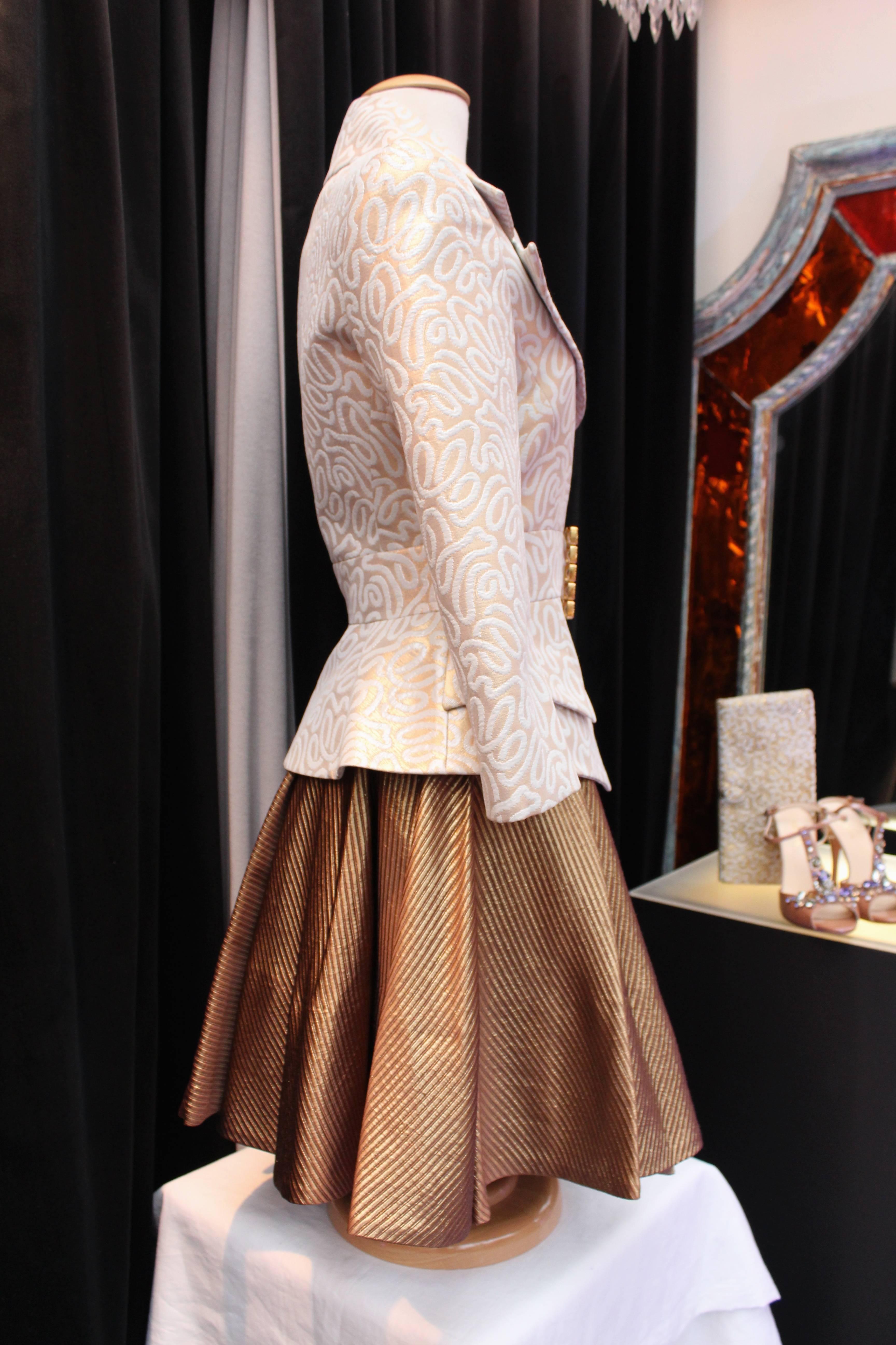 TED LAPIDUS HAUTE COUTURE (Paris) Ensemble composed of a pleated skirt in gold and tabacco silk brocarde and its matching jacket in ivory and gold silk brocarde. 

The jacket features an integrated belt in trompe-l'oeil with a gold and crystals