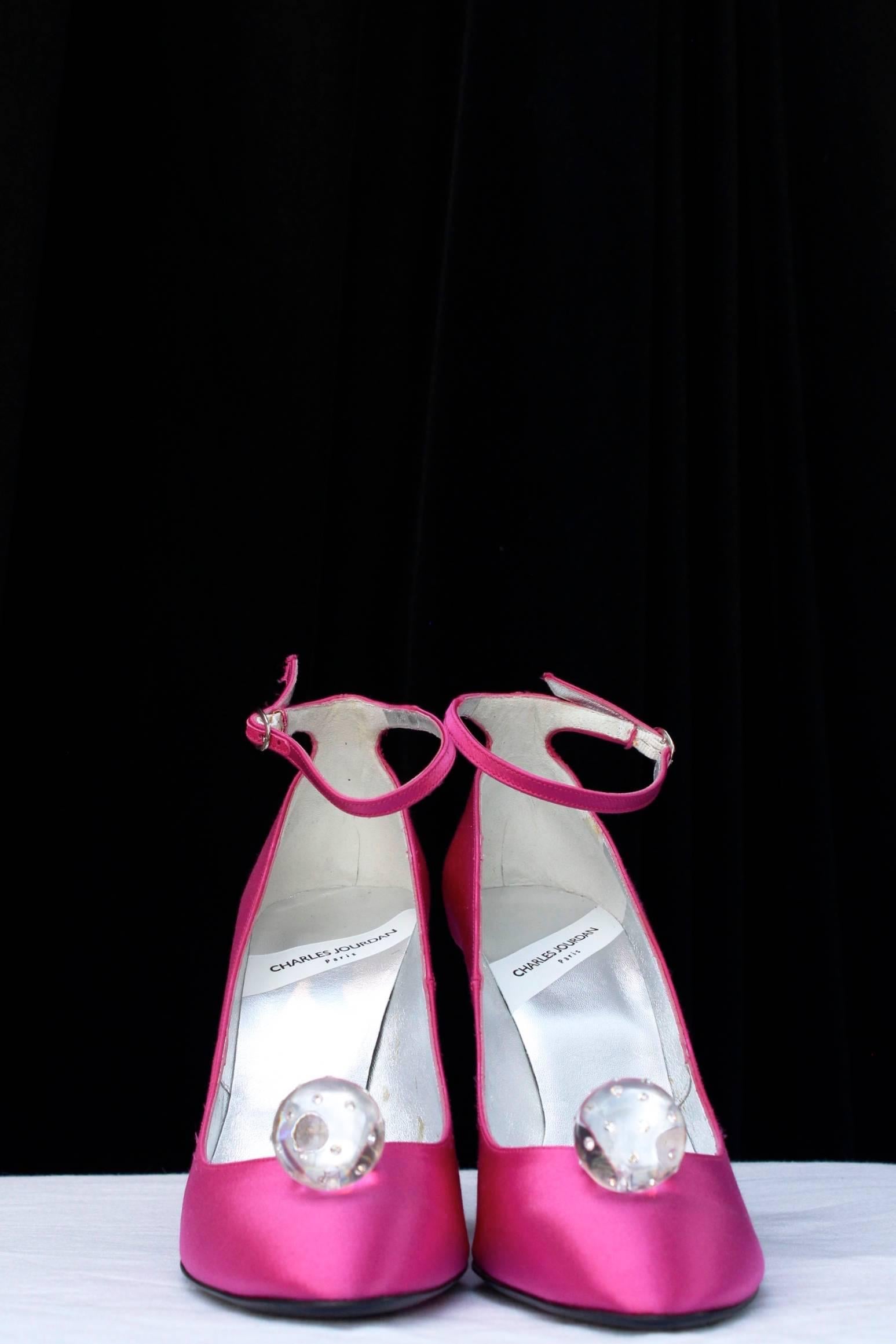CHARLES JOURDAN (Made in France) Sling back pumps composed of fuchsia satin, decorated at front with a transparent sphere inlaid with rhinestones. Identical spheres decorate the heels. Silver color leather inner sole, black leather outer sole.

They