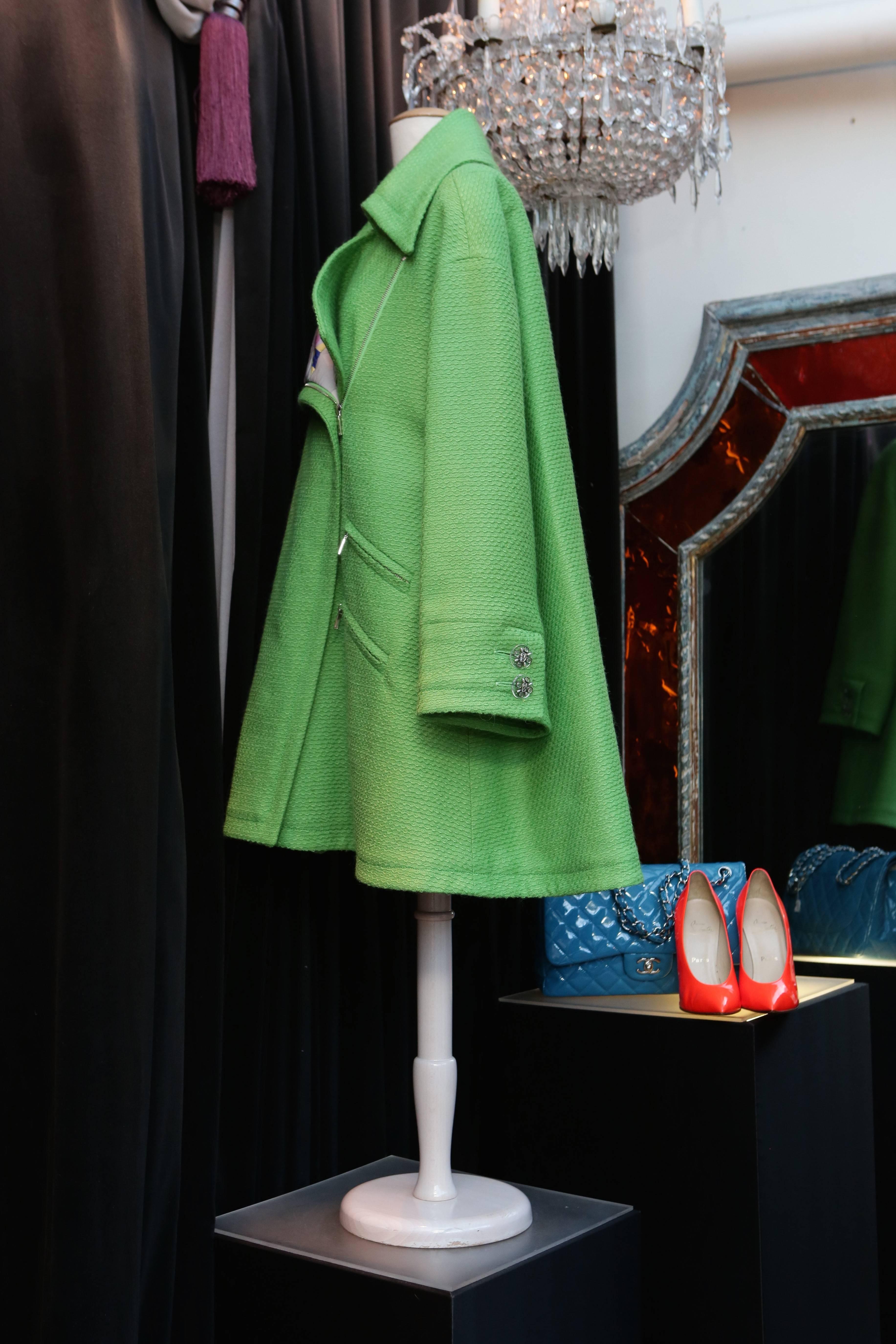 CHANEL (Made in France) Oversize apple-green wool coat withe a wide collar. Four side pockets with silver plated zip closure. The unique lining is made out of quilted silk printed with colored patterns in the style of Robert Delaunay’s works and