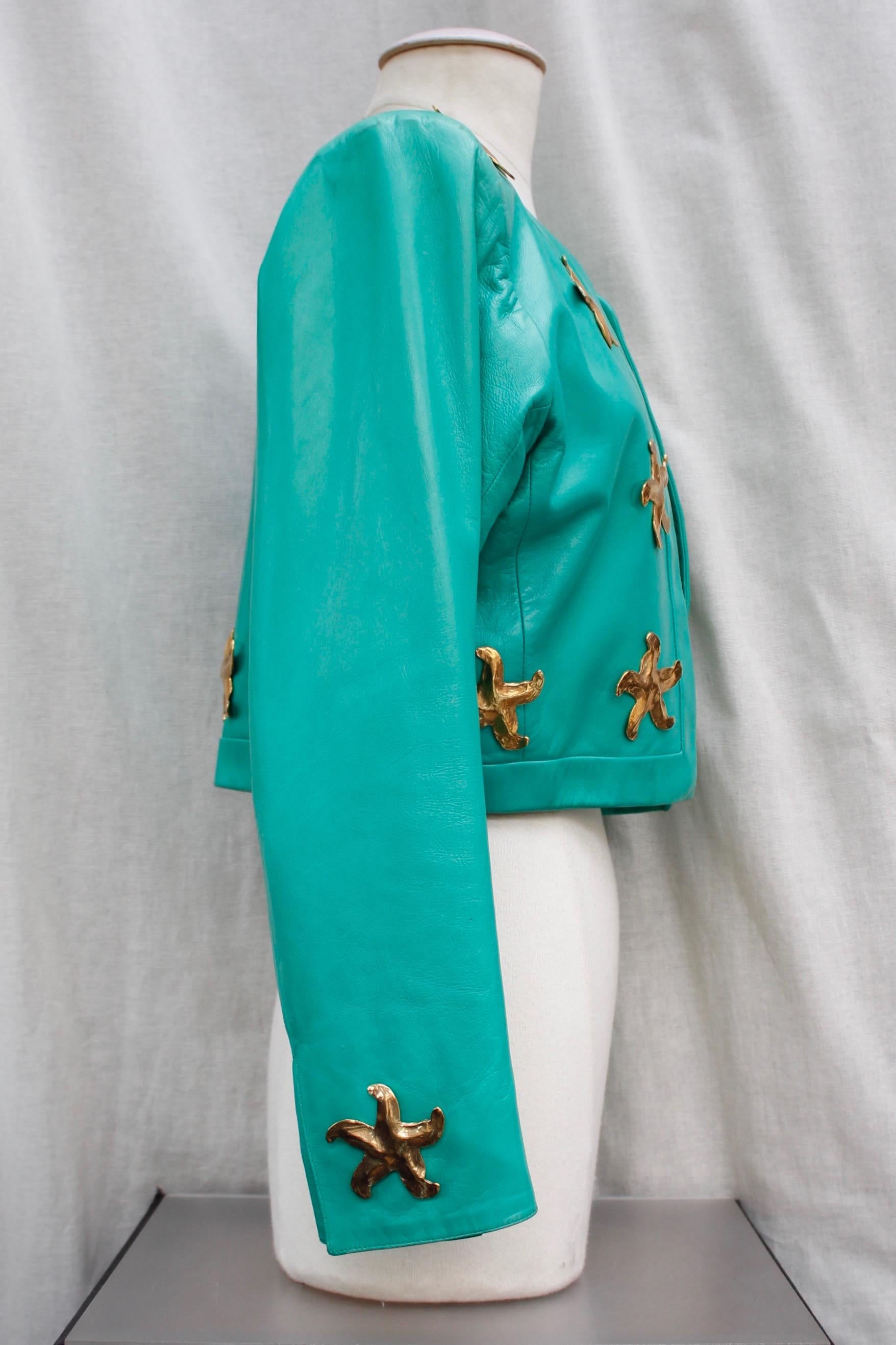 YVES SAINT LAURENT RIVE GAUCHE (Made in France) Beautiful long sleeve short jacket composed of turquoise/green lambskin. No collar.  It is decorated with large gilded metal starfish. Synthetic lining.

Circa 1980’s.

No indicated size, fits a 38 (US