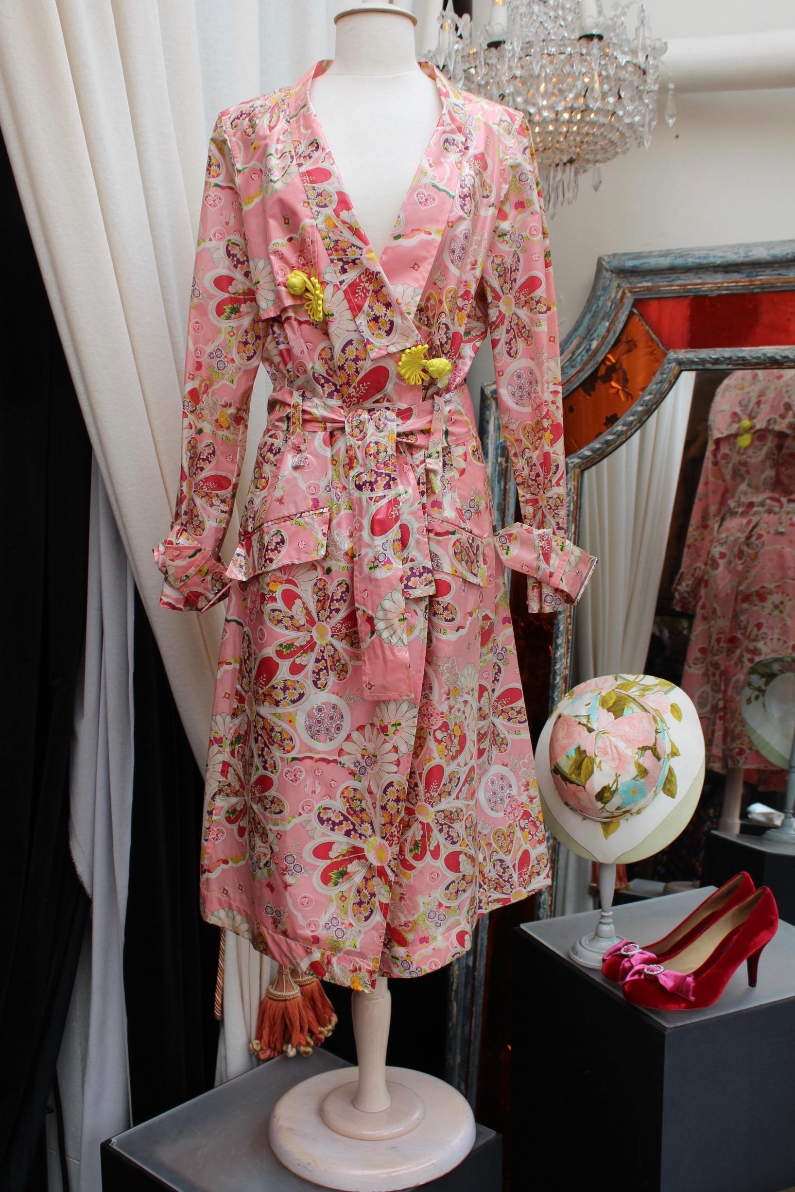 JOHN GALLIANO (Made in France) Gorgeous set comprised of a long trench coat and a high rise pair of flared pants. The set is composed of pink silk  with patterns representing cherries, hearts and flowers in a Japanese style, in yellow, purple, green