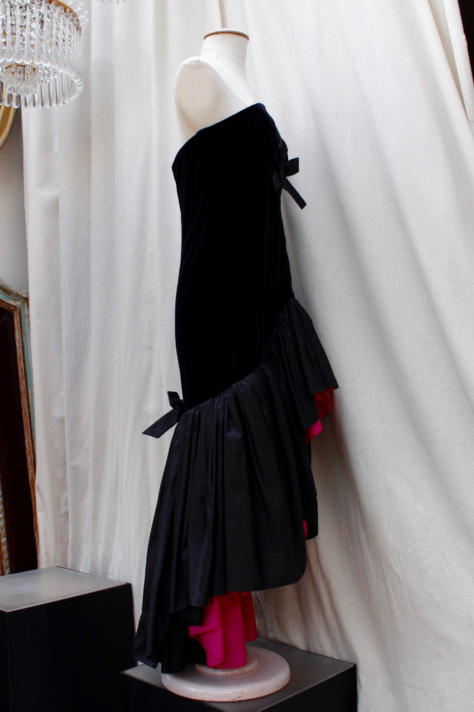 Yves Saint Laurent Rive Gauche (Made in France)  Exceptional bustier cocktail dress composed of layers of black tulle, in a 1950’s style; it is cinched by a wide black satin bow and features a very feminine heart-shaped neckline.

The dress is