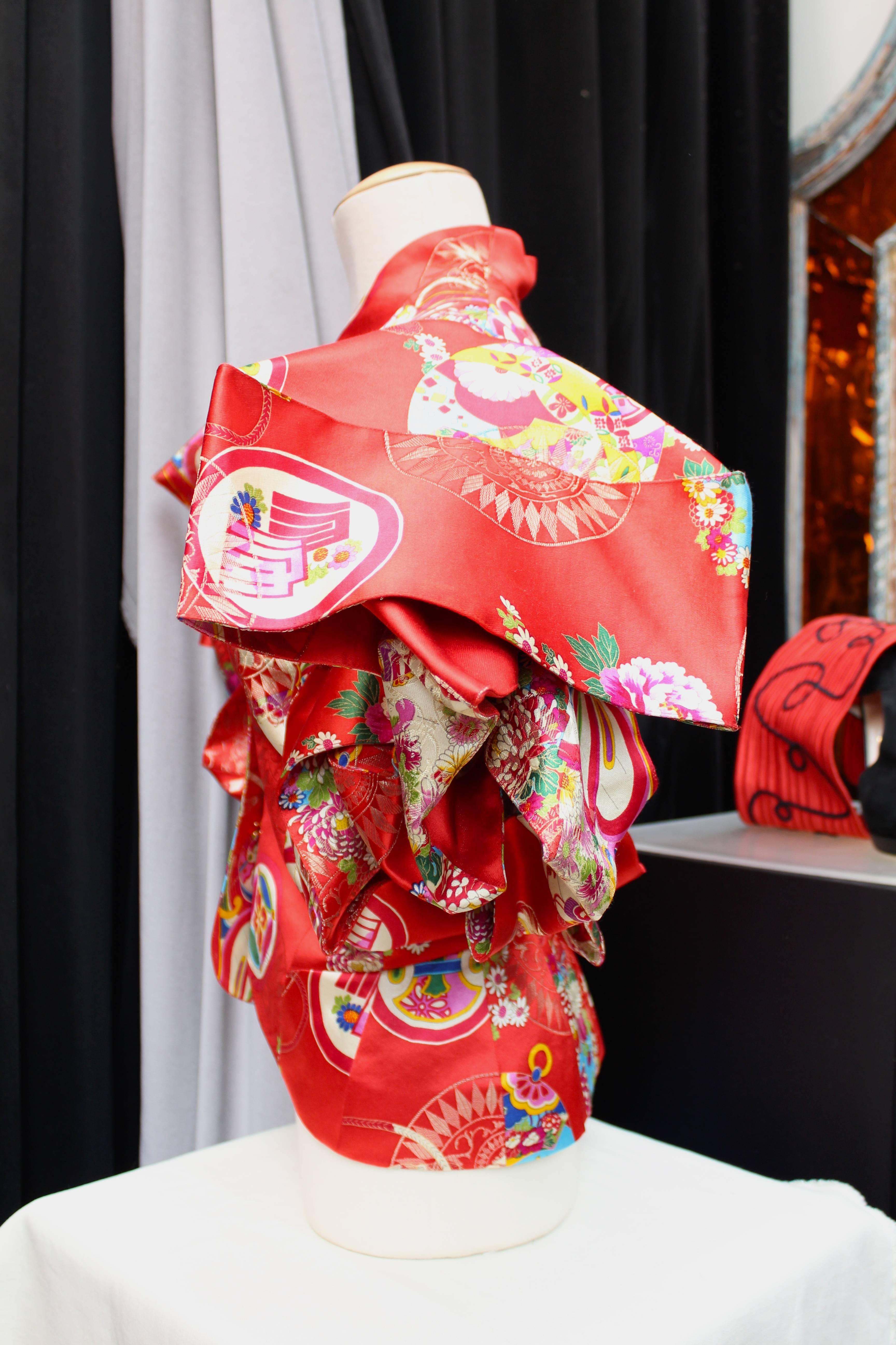 CHRISTIAN DIOR BOUTIQUE (Paris) Red silk jacket printed with kimono style design featuring dramatized voluminous 3-D cutting short sleeves in the style of chinese folkloric kites. 

The jacket closes in the front with a series of invisible gold