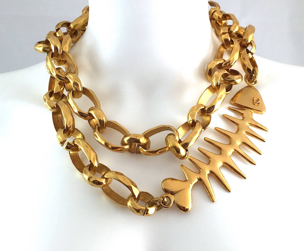 Important CHANEL vintage couture deco gold-tone massive chain necklace with fishbone motif. The fish bone features a heart shaped tail and CC logo eye. The necklace consists of large circular links and has a hook closure. It is stamped Chanel and is