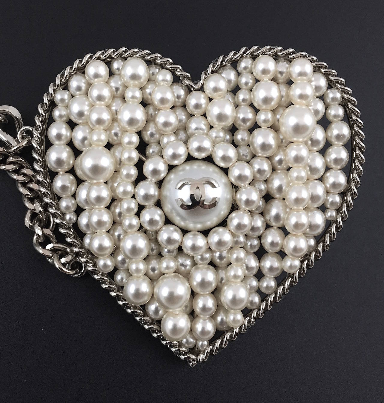 Stunning Chanel faux pearl silver-tone multi-chain sautoir belt with hand strung pearls encased in a large heart pendant. The belt has a hook closure and is adjustable. This rare, elegant belt is from the Fall 2006 Collection.  It is in pre-owned