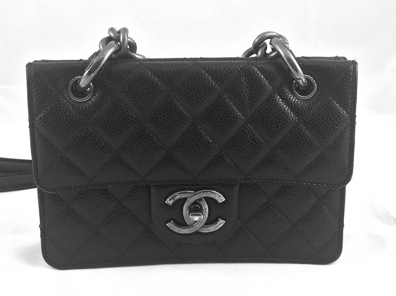 Limited edition Chanel black caviar retro flap shoulder bag with aged silver-tone hardware, curb chain strap, removable leather shoulder strap, front flap CC turn lock closure, and separate back zippered pouch. Red fabric interior. Includes dust