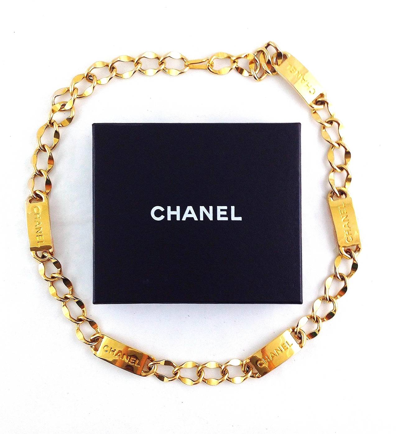 Iconic Chanel gold-tone chain necklace with five Chanel ID plaques and hook closure. Can also be worn as a belt. Comes with box, circa 1980s.

Approxmately 30