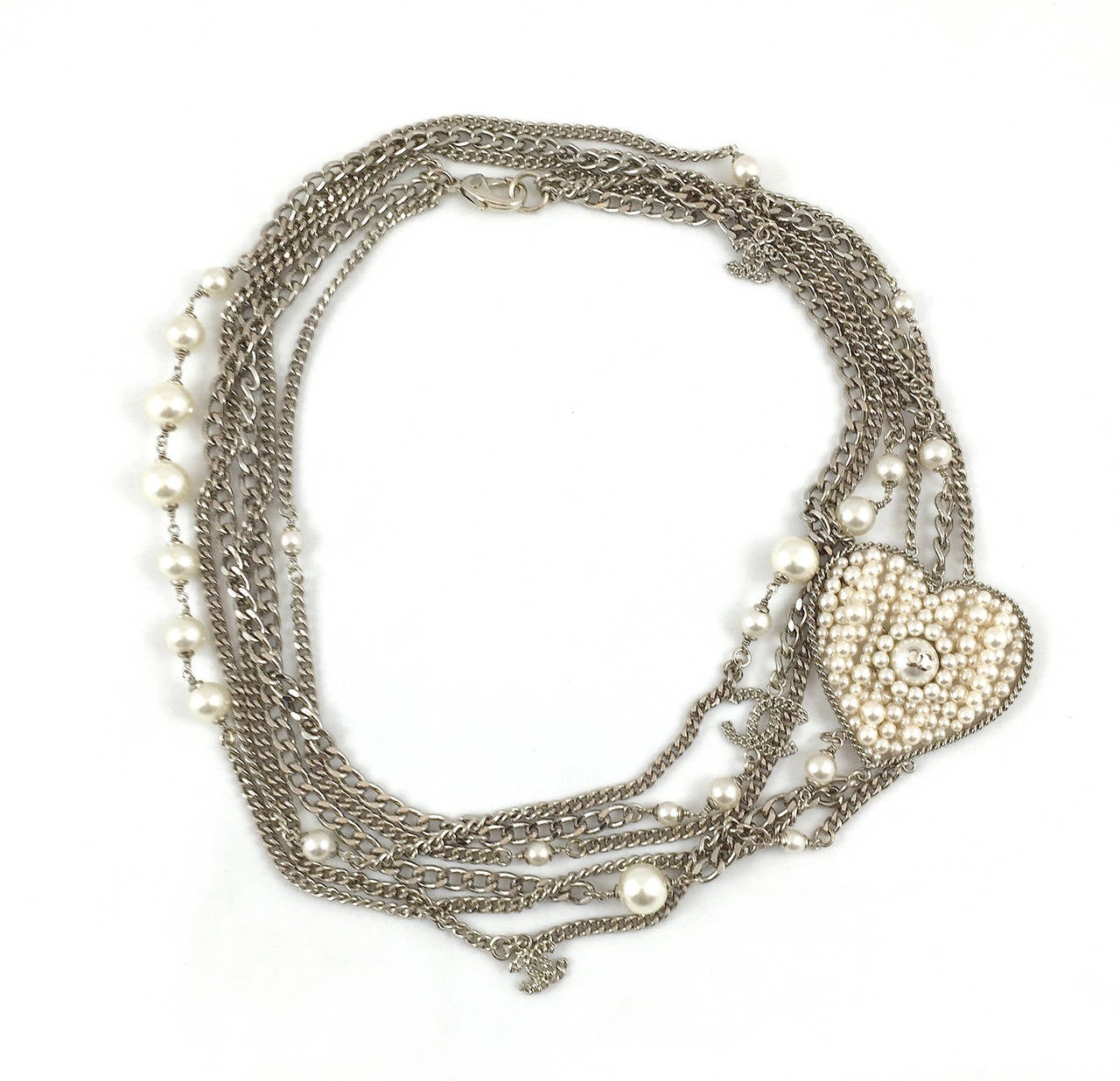 Stunning Chanel faux pearl silver-tone multi-chain sautoir extra long necklace with hand strung pearls encased in a large heart pendant. This rare, elegant necklace is from the Fall 2006 Collection. 

Measurements:
Length 48