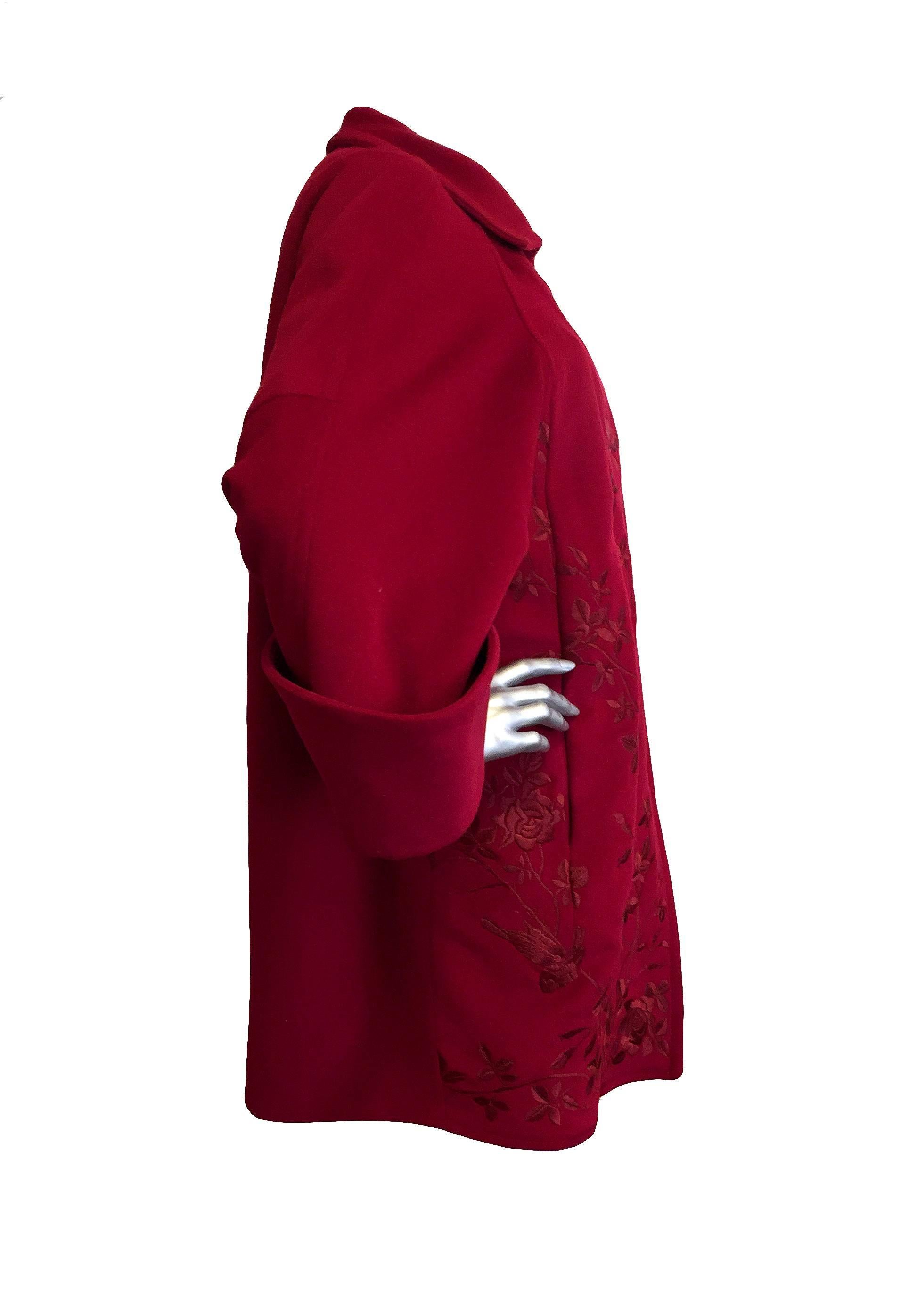 Christian Lacroix burgundy wool and cashmere coat with one button at neckline, intricate floral embroidery, wide cuffed sleeves, pockets, and jacquard lining.