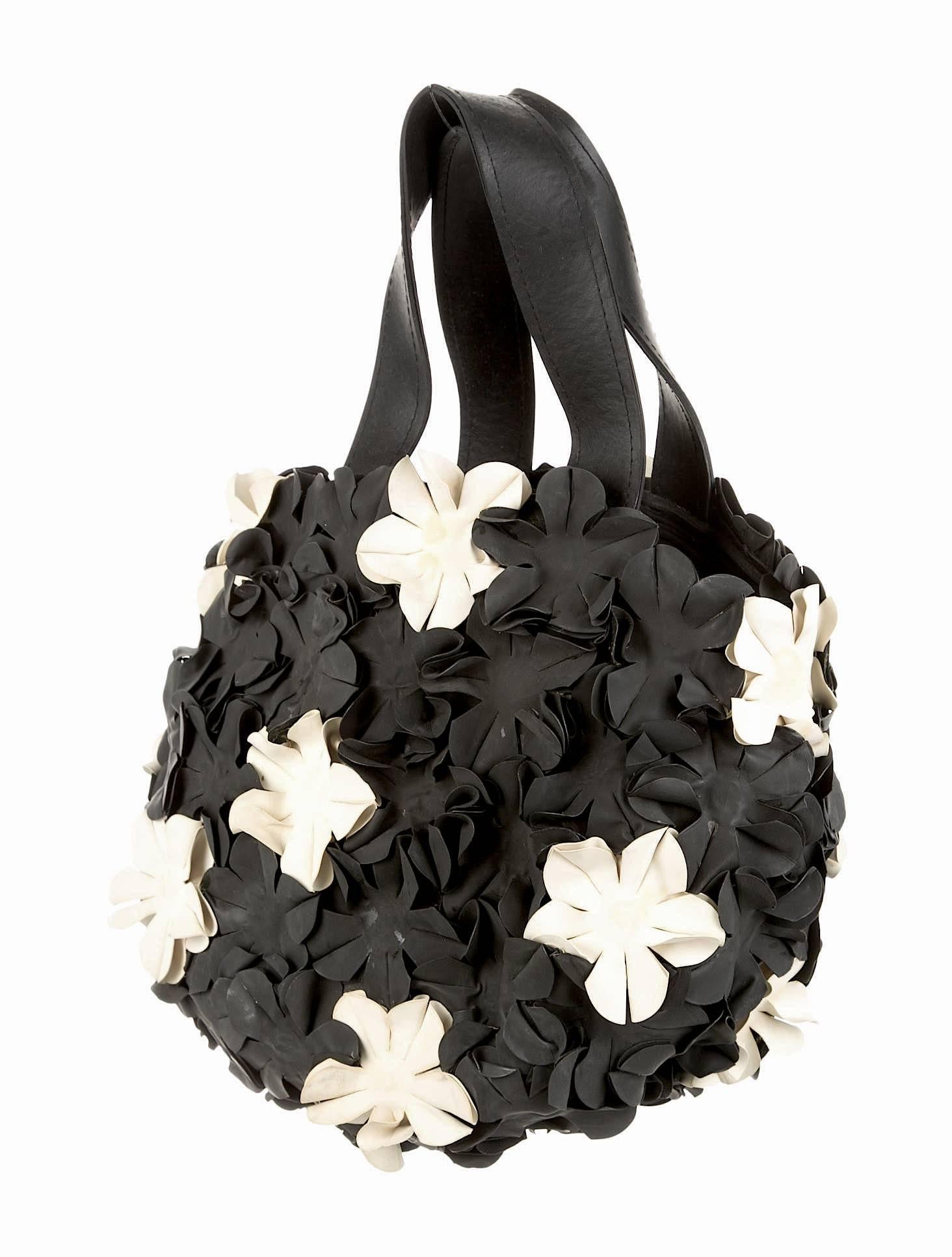 Black rubber Comme des Garçons handle bag with black and white flower appliqués throughout, flat handles and open top. 

Measurements: Handle Drop 5”, Height 8”, Width 9.5”, Depth 4”