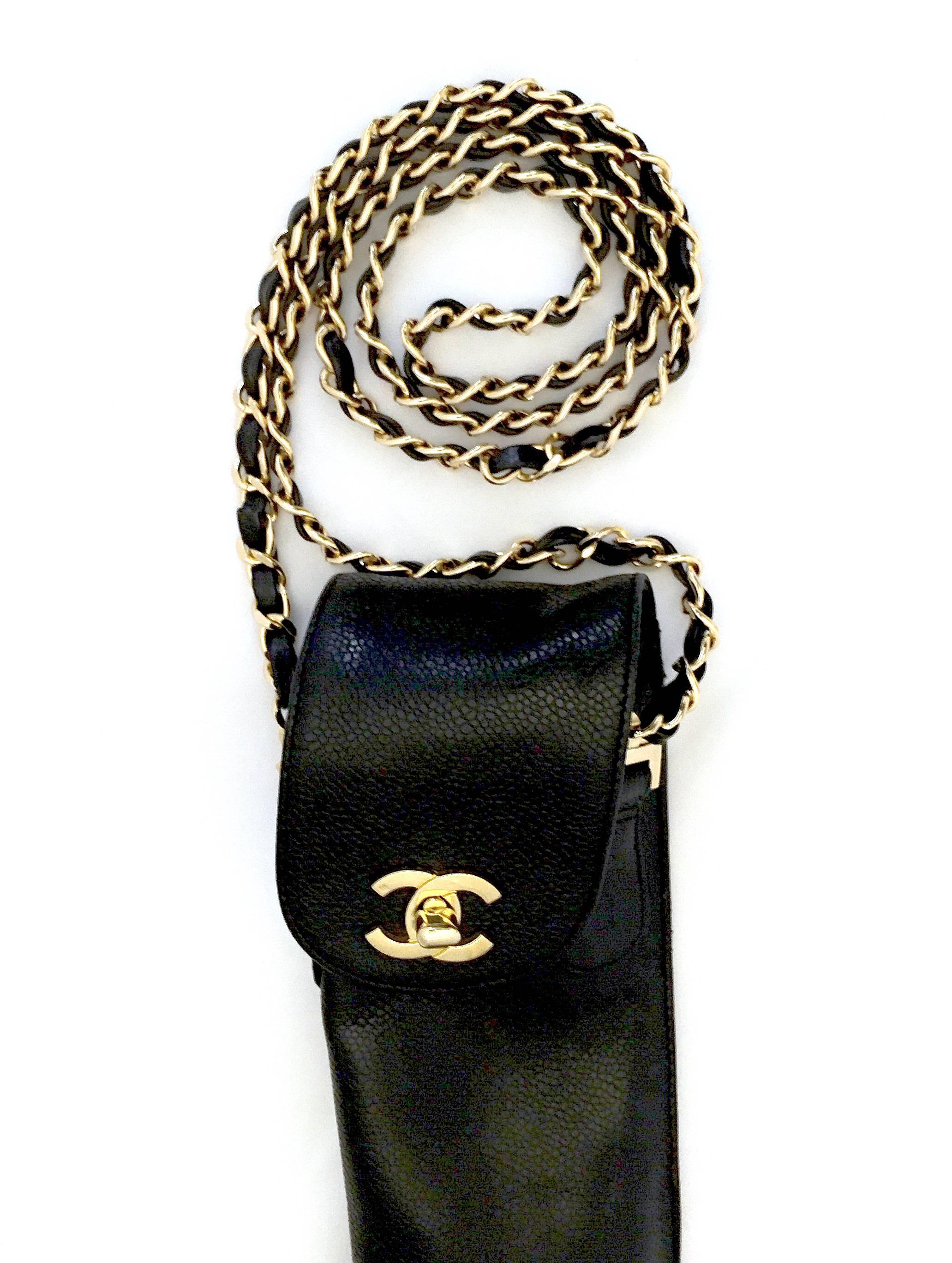 Chanel black caviar leather umbrella case from 1995 with gold-tone hardware, front flap and CC turn-lock closure, chain and leather strap, and slide back pocket. Does not include umbrella.

Measurements:  Handle Drop 21”, Height 17”, Width 3”