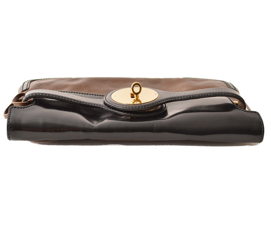 A beautiful Balenciaga black, brown & gold medallion clutch handbag.  Interior divided into two parts with one open pocket. Features attached mirror in matching brown leather frame with pocket on the back. Mirror attached with matching brown leather